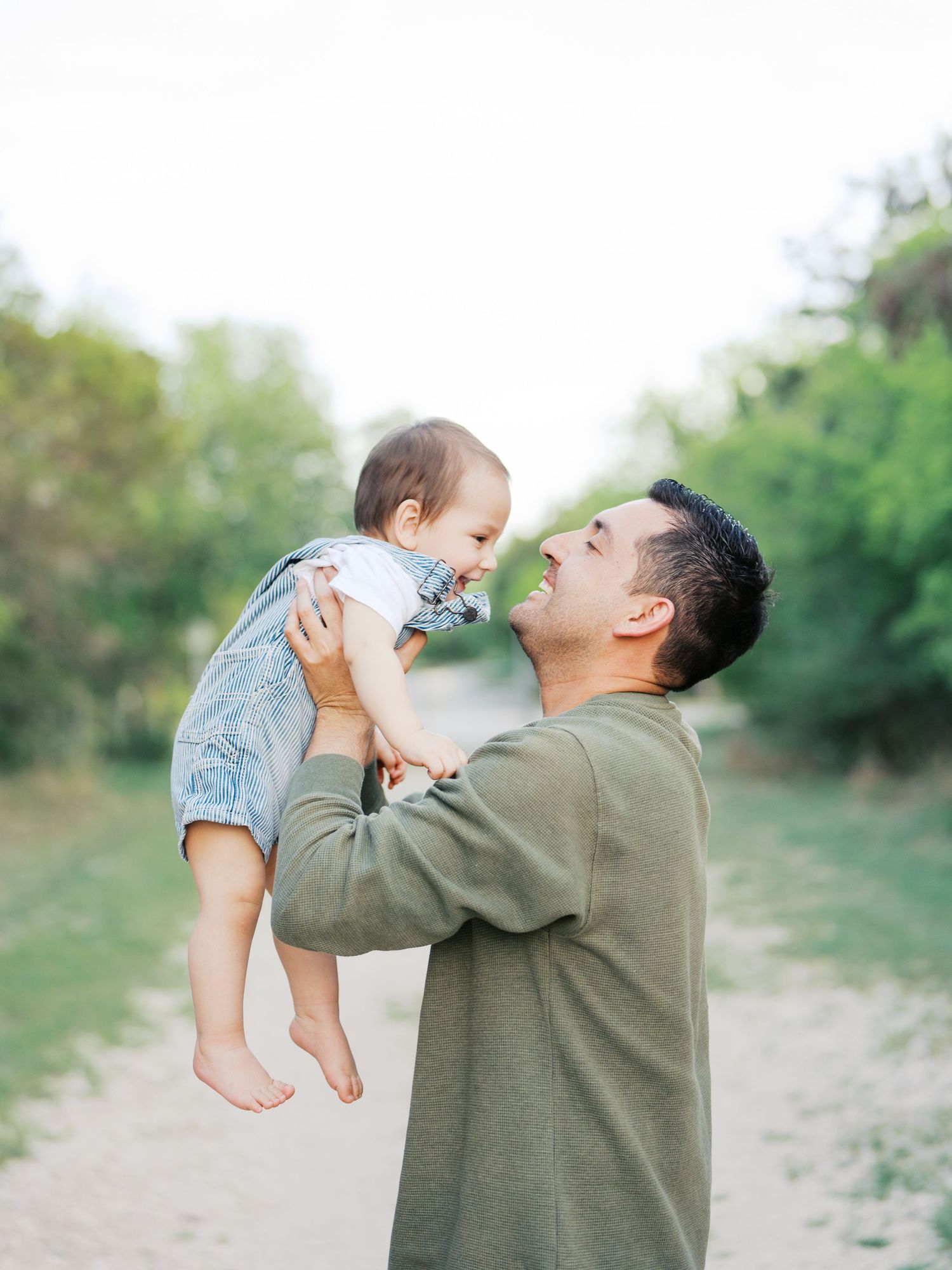 Dad carrying his baby during a one year old outdoor milestone session.