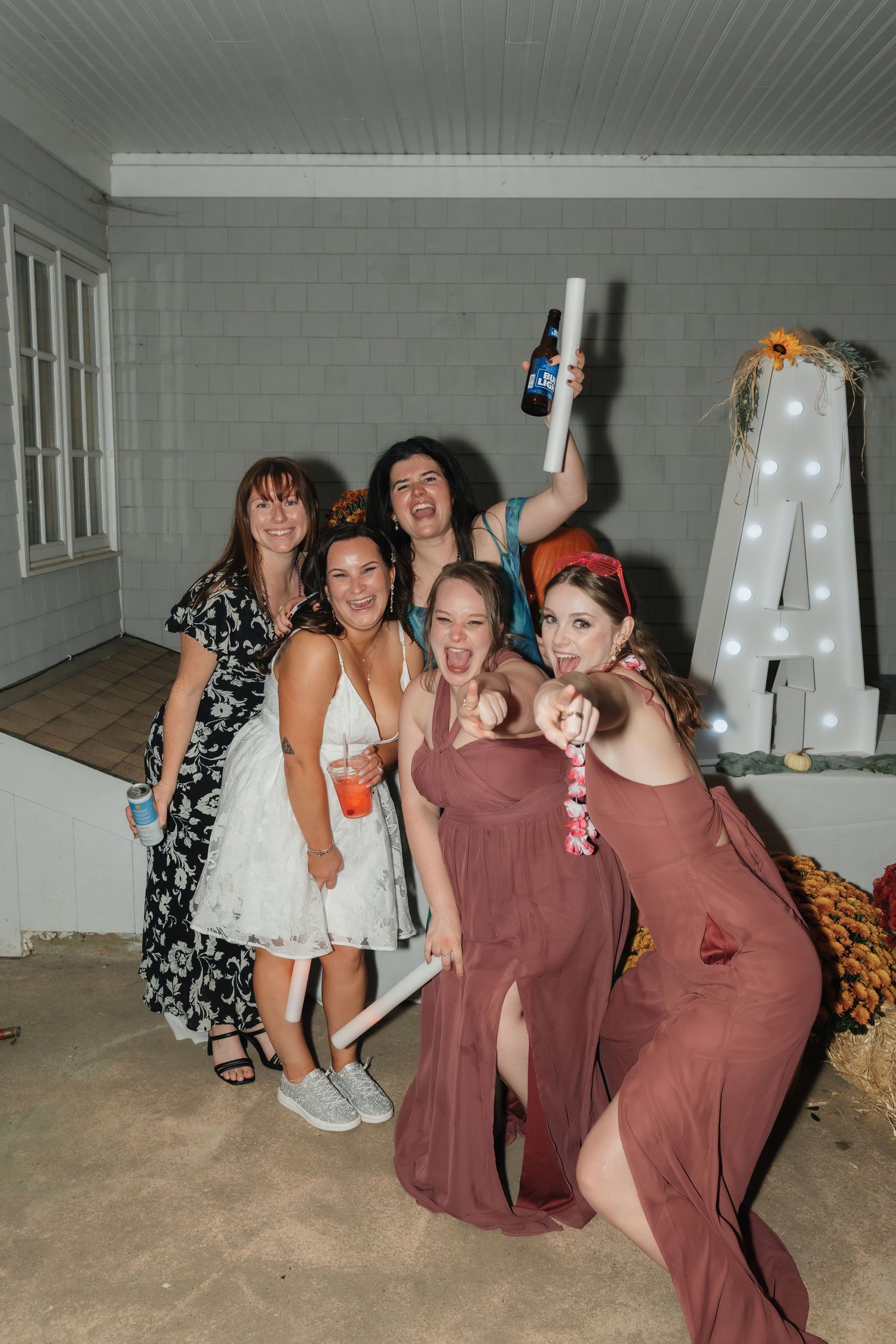 Wedding reception party scene with illuminated letter decor and dancing guests.