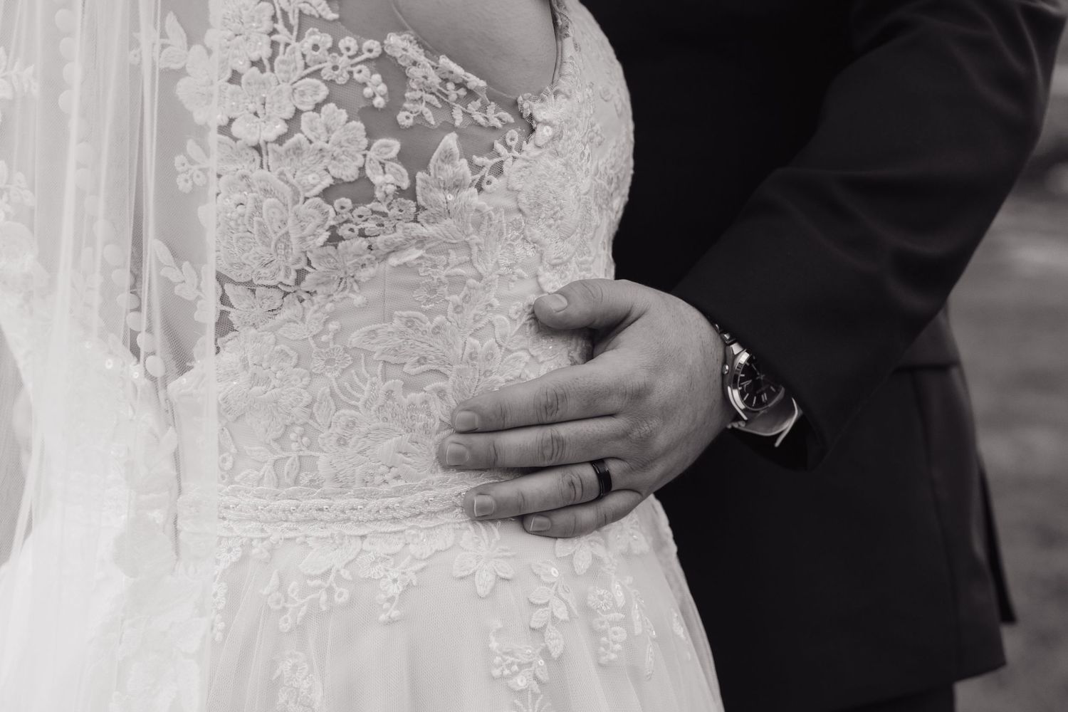 Close-up detail of intricate lace wedding dress beadwork and embellishments.
