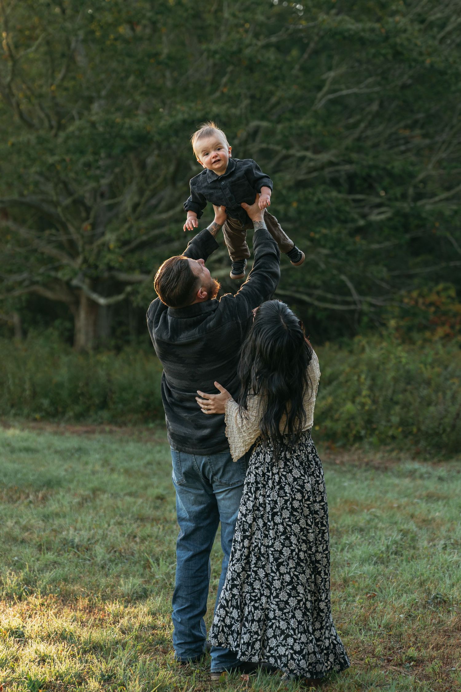 Family shares playful moments during autumn outdoor photoshoot.