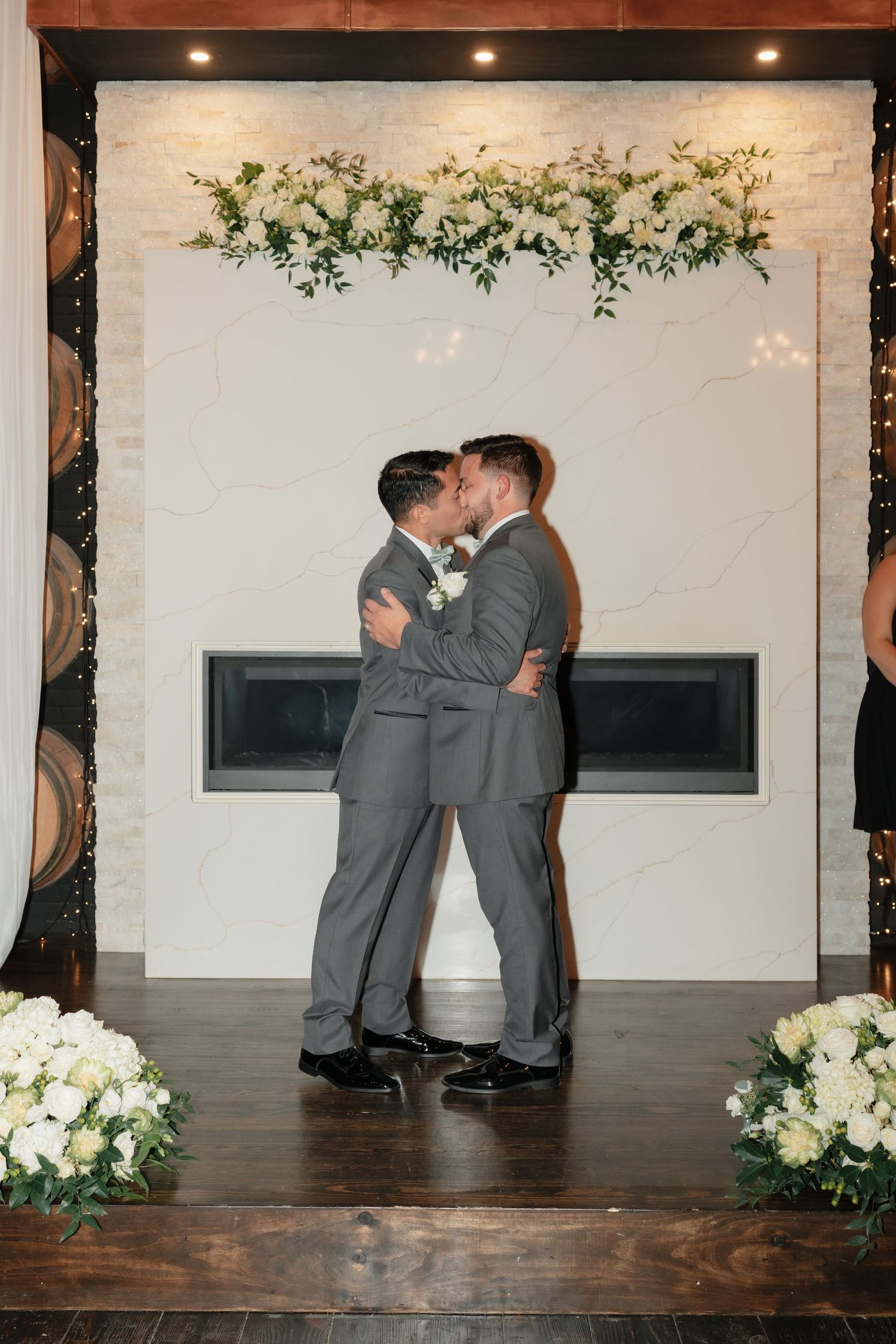 Wedding ceremony moment under an elegant floral arch with white flowers.