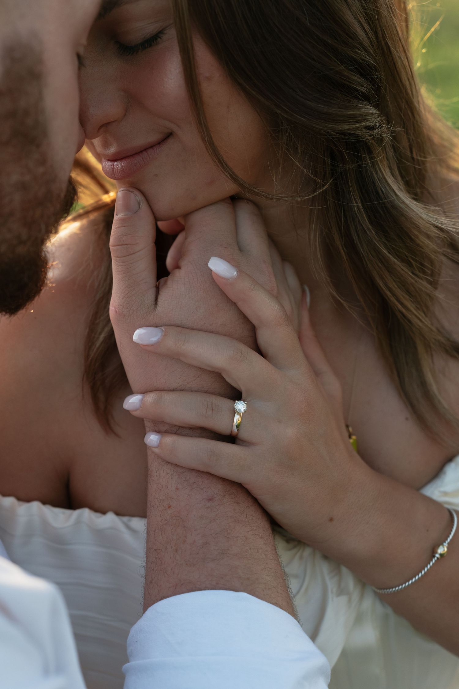 Close-up of tender romantic moment with white manicured nails visible.