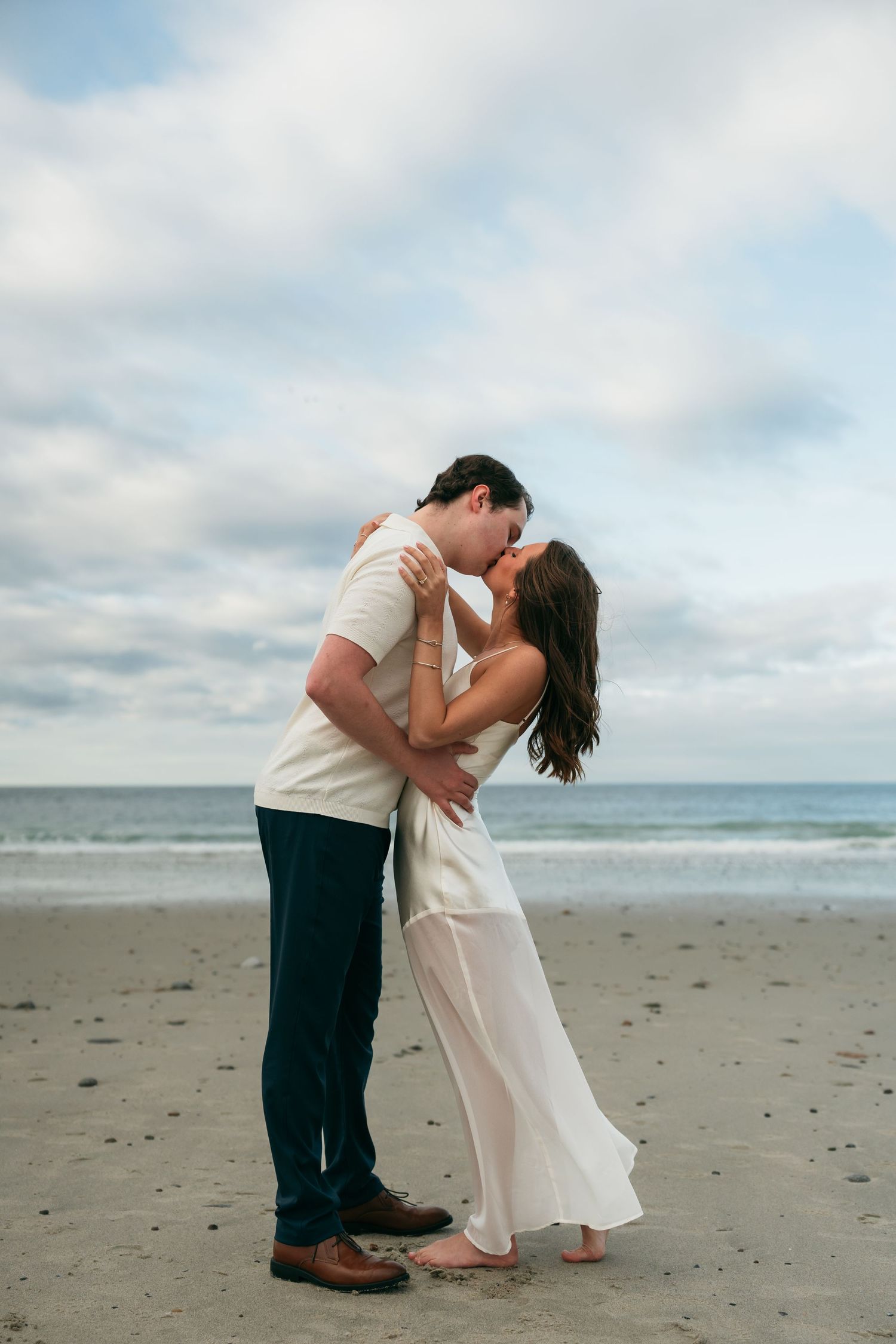 A couple sharing an intimate dance dip pose on the beach.