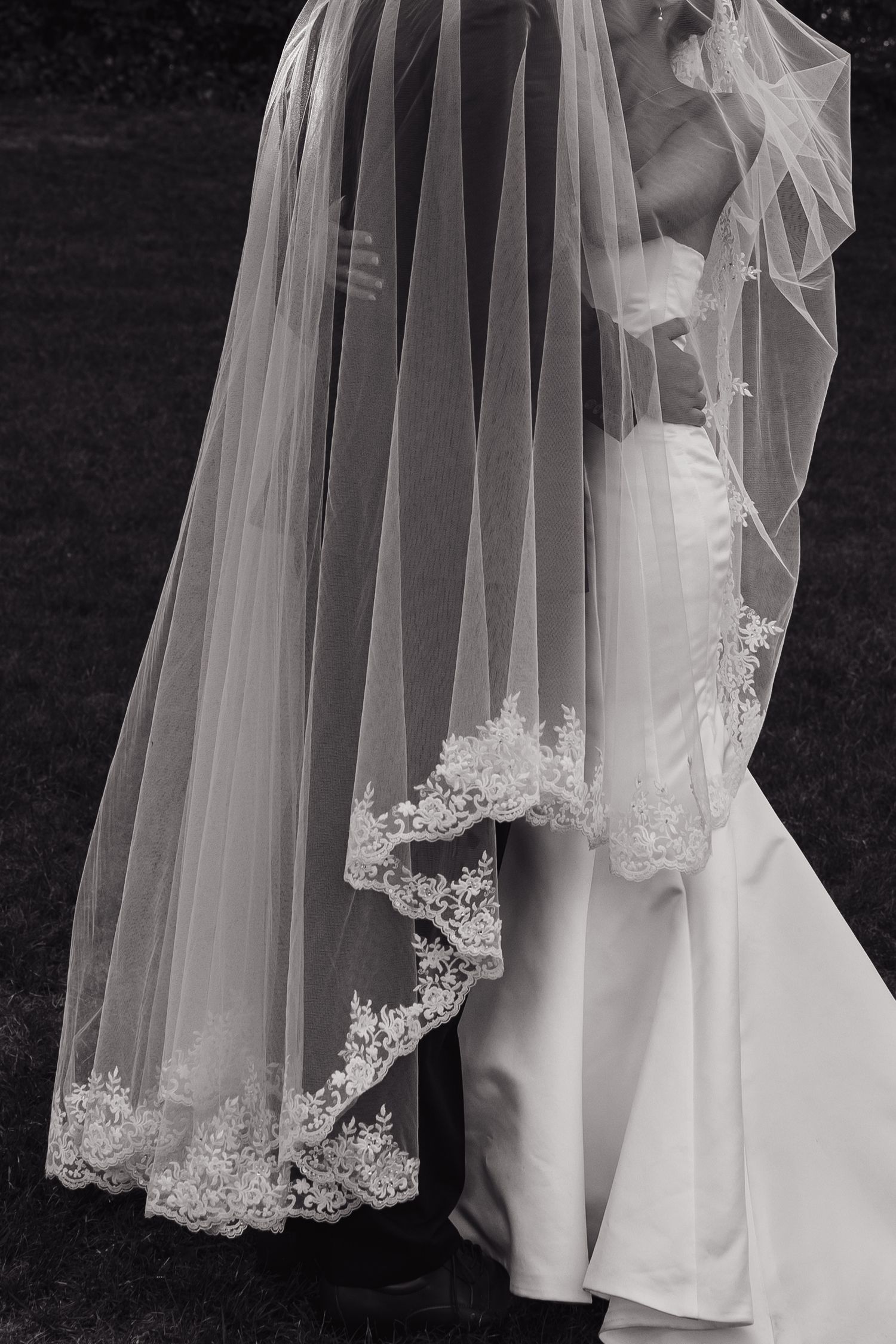 Delicate lace trim detail on flowing white wedding veil.