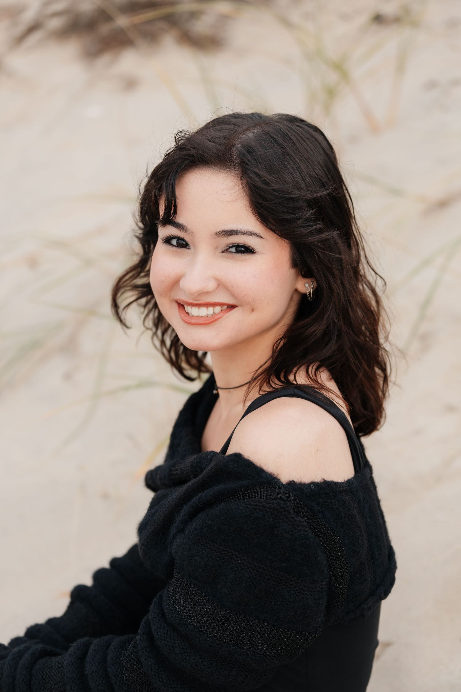 Casual outdoor portraits featuring someone in a cozy black sweater against a natural backdrop.