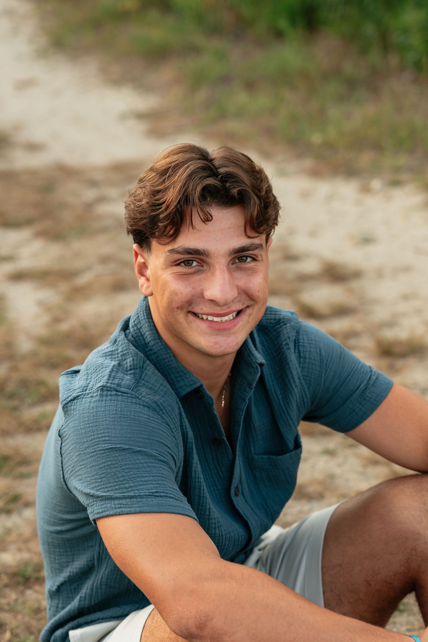 Candid outdoor portrait in blue casual shirt during golden hour.