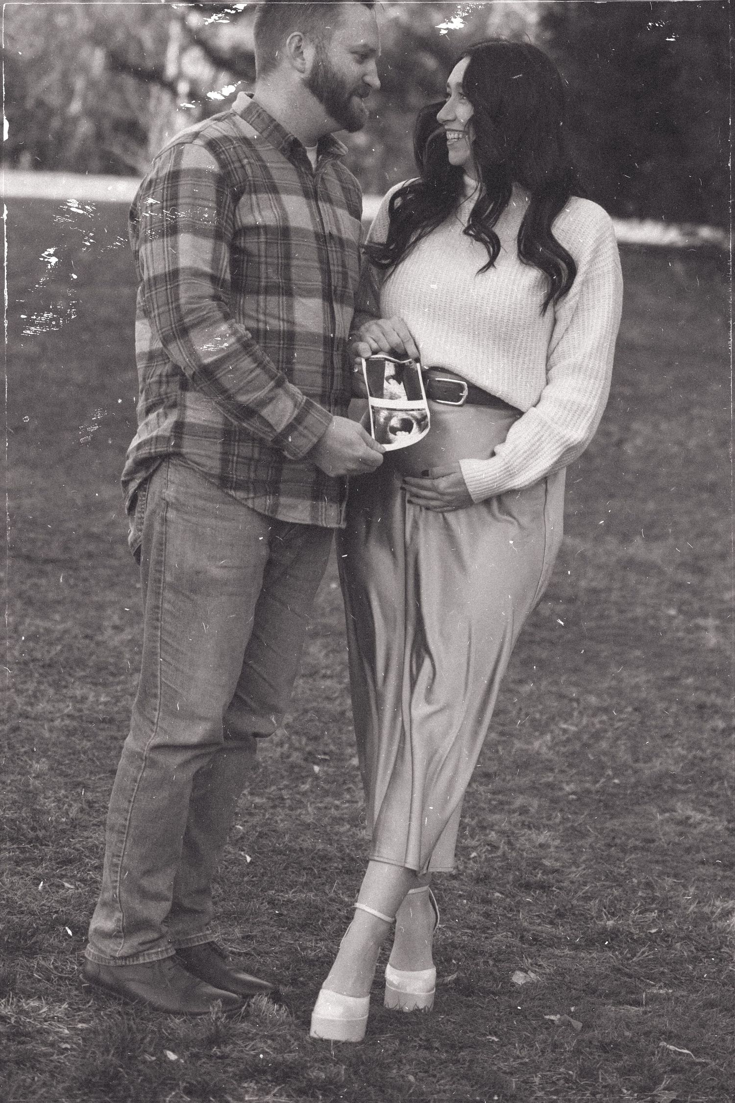 Black and white couple's portrait in casual outdoor setting.
