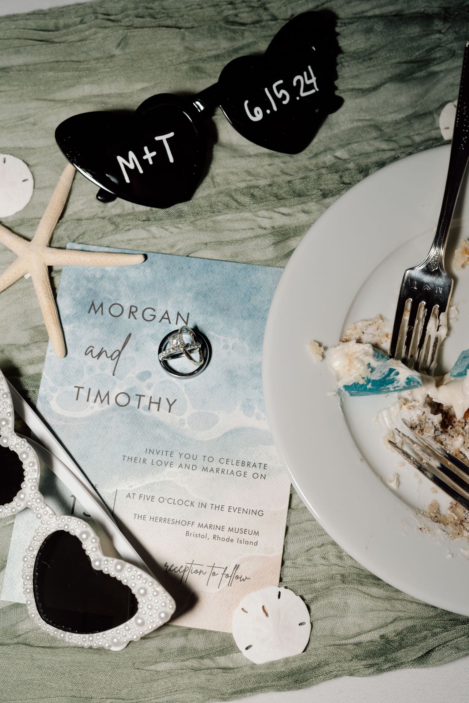 Wedding invitation suite with starfish and nautical elements on weathered wood background.