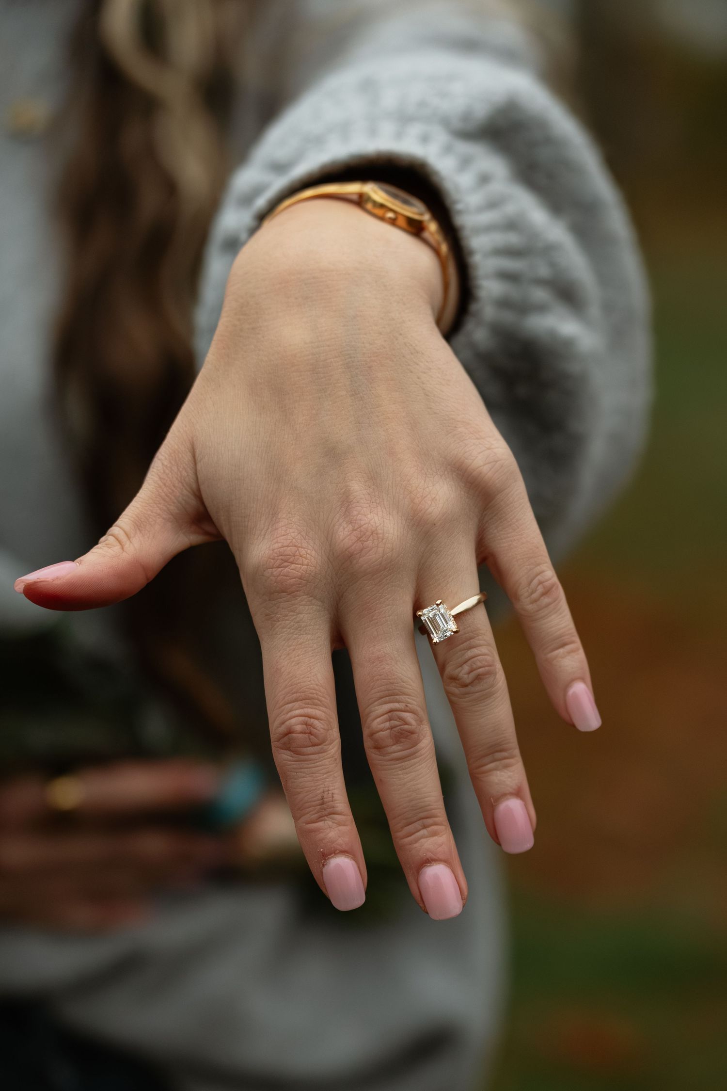 Close-up shot of a hand wearing a sparkling engagement ring.