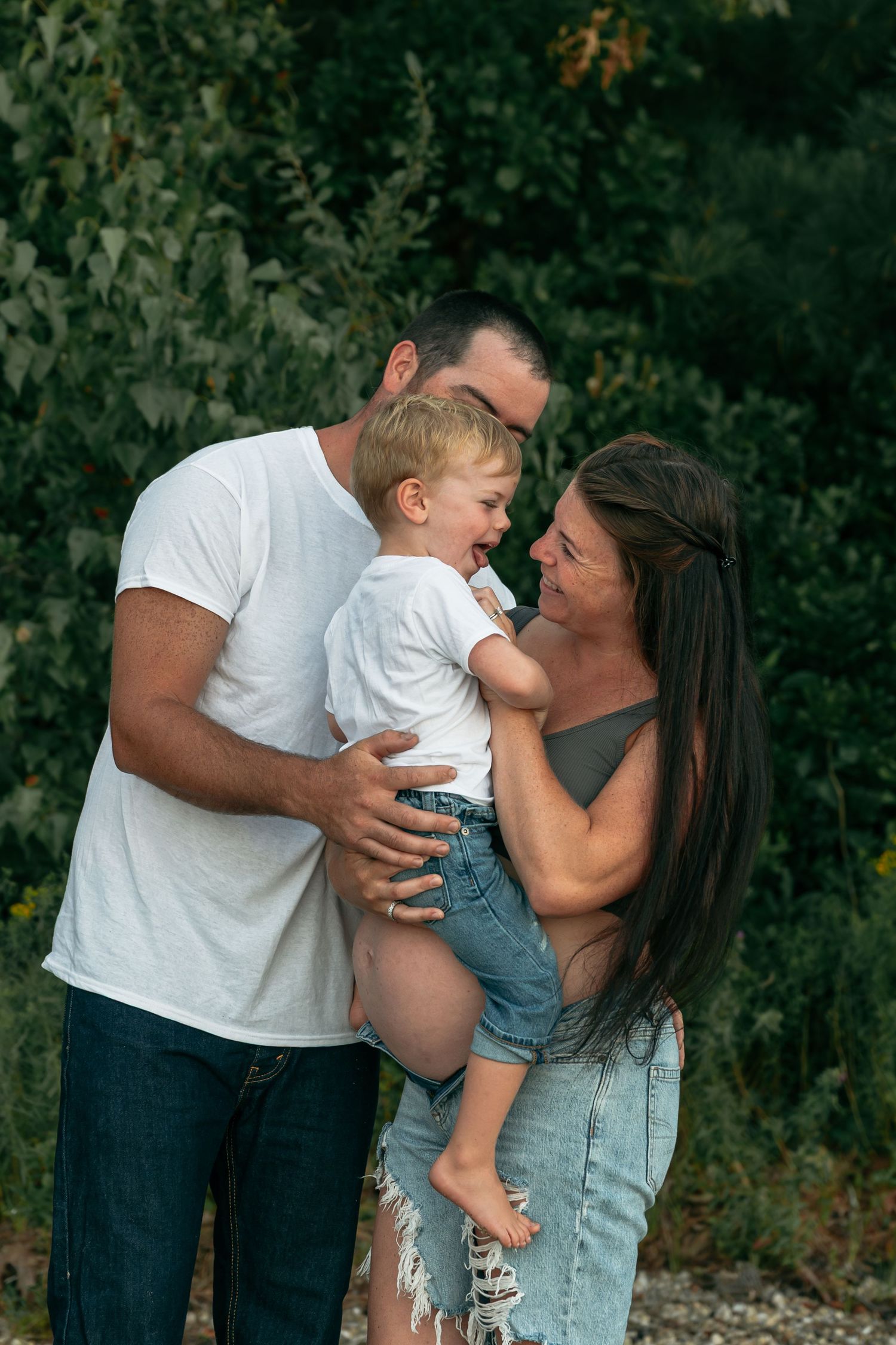 An intimate family portrait showing tender moments and laughter in a natural setting.