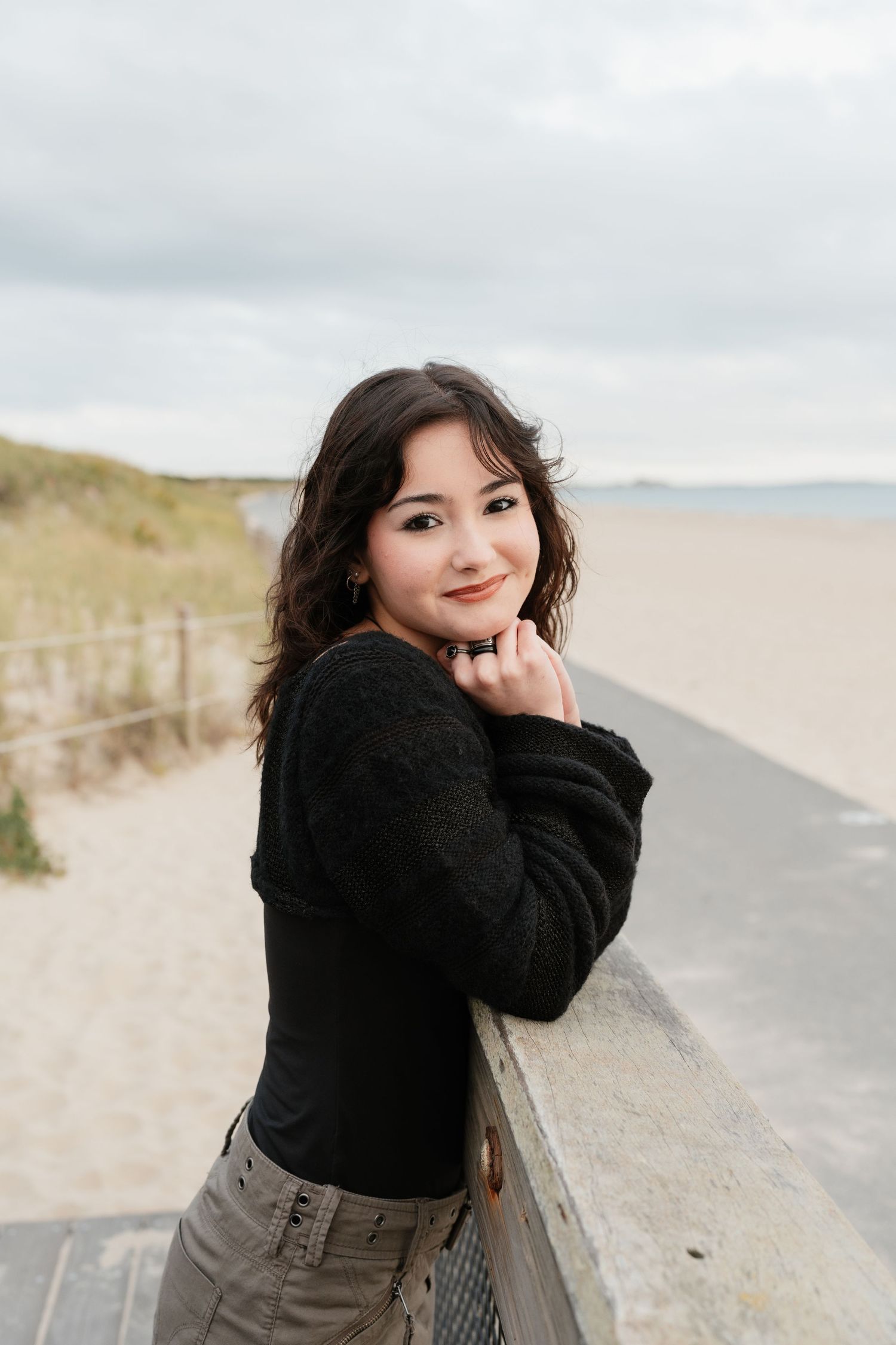 Candid outdoor portraits on a beach path with someone in a black sweater.