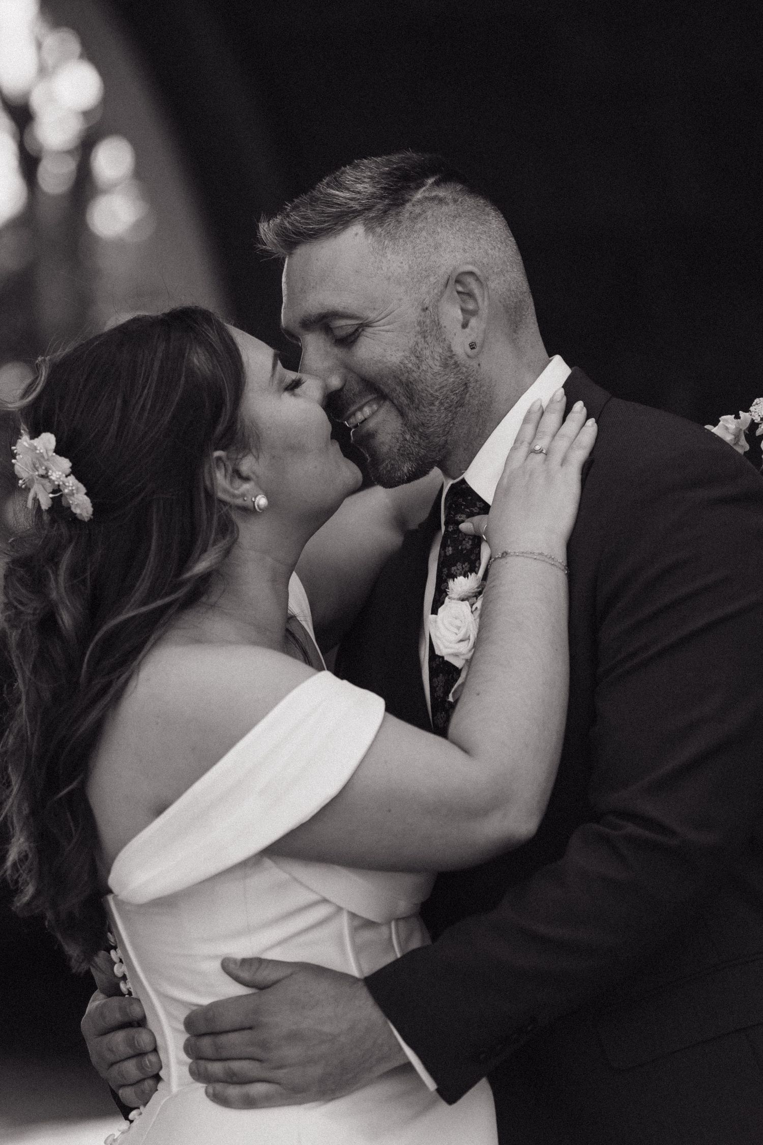 Intimate black and white portrait of newlyweds sharing tender moment.