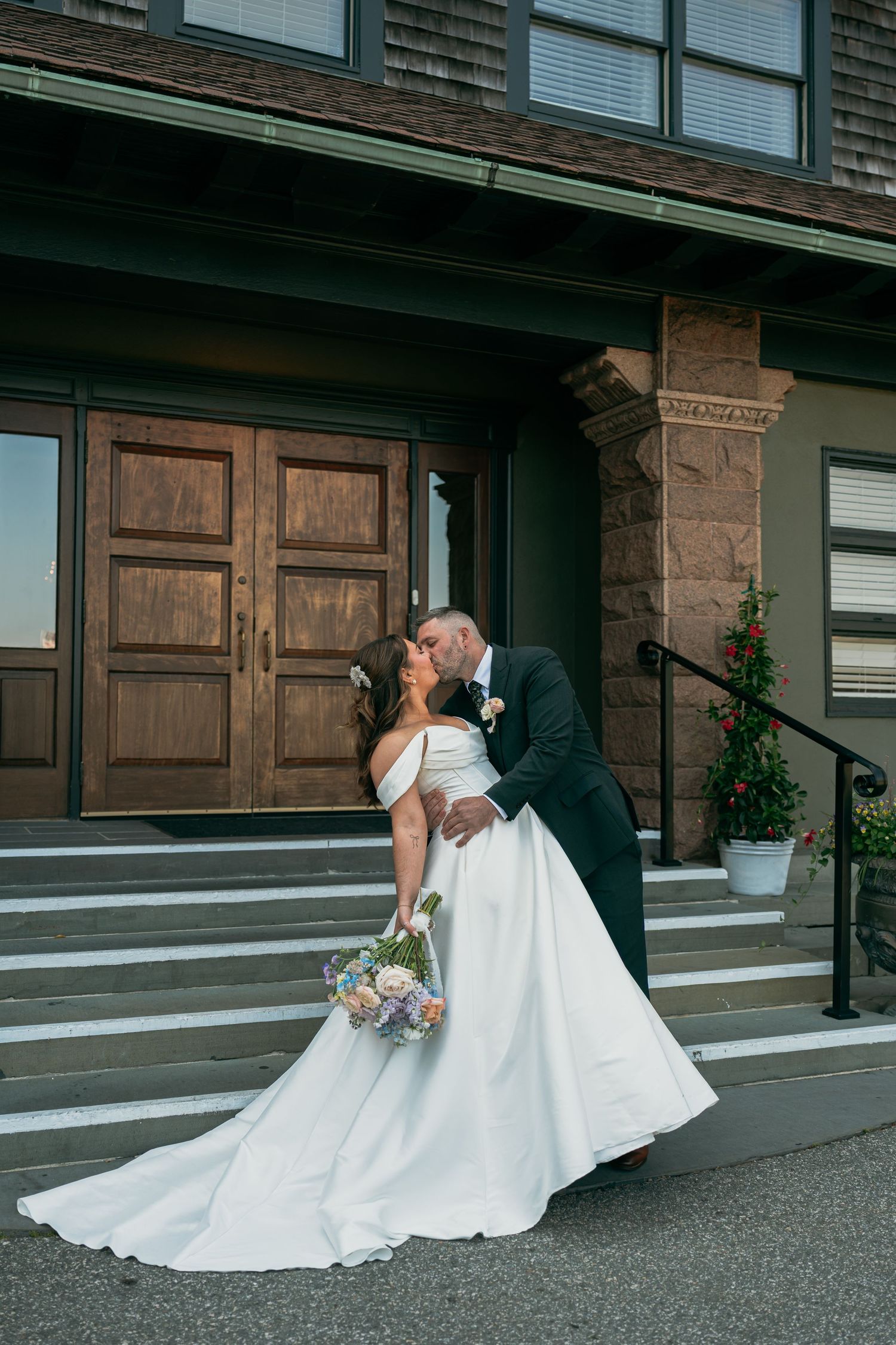 Elegant wedding portraits showing couple posing on stone building steps.