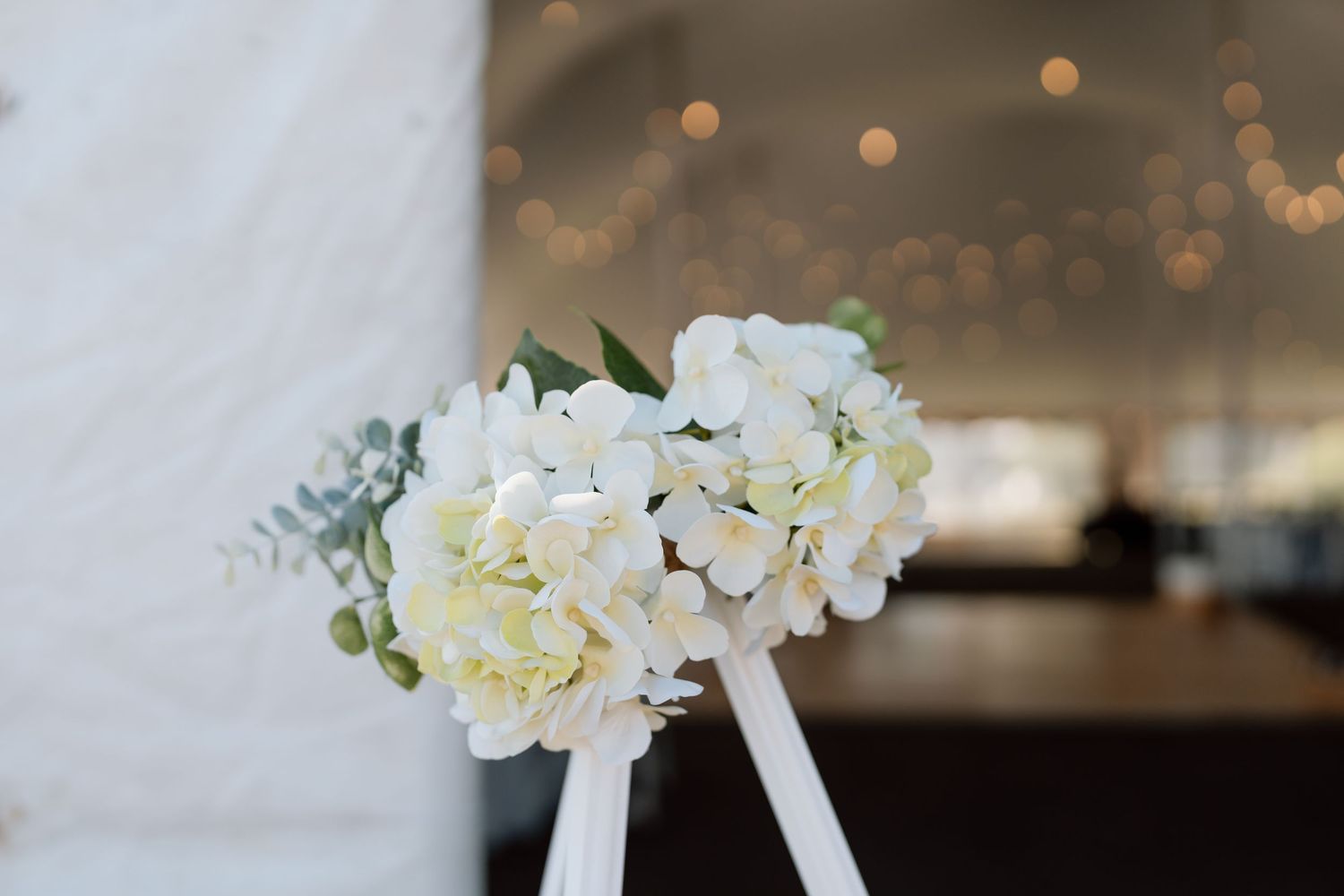Elegant white floral arrangements with orchids and greenery for wedding decor.