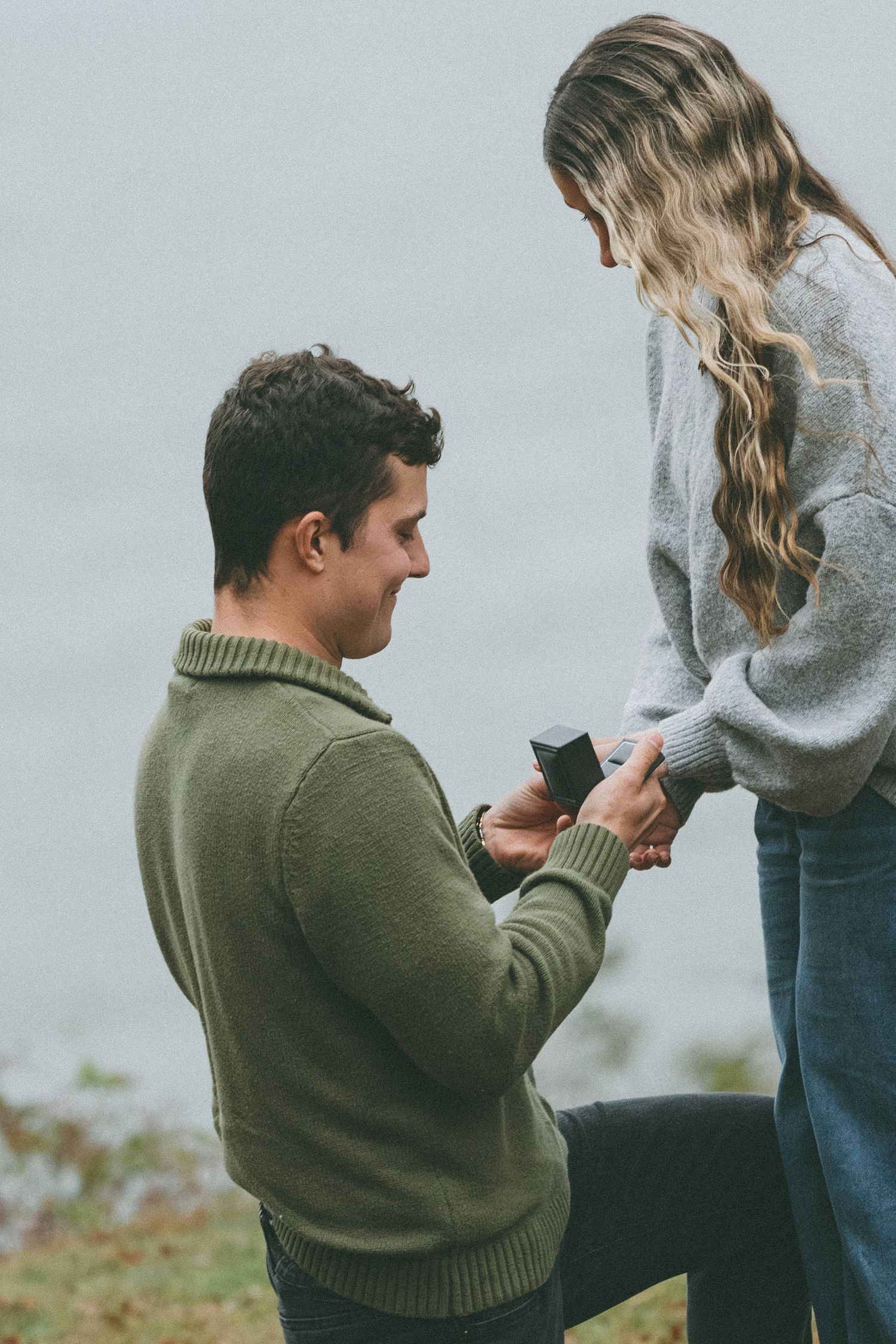 Marriage proposal moment captured in autumn setting with person kneeling.