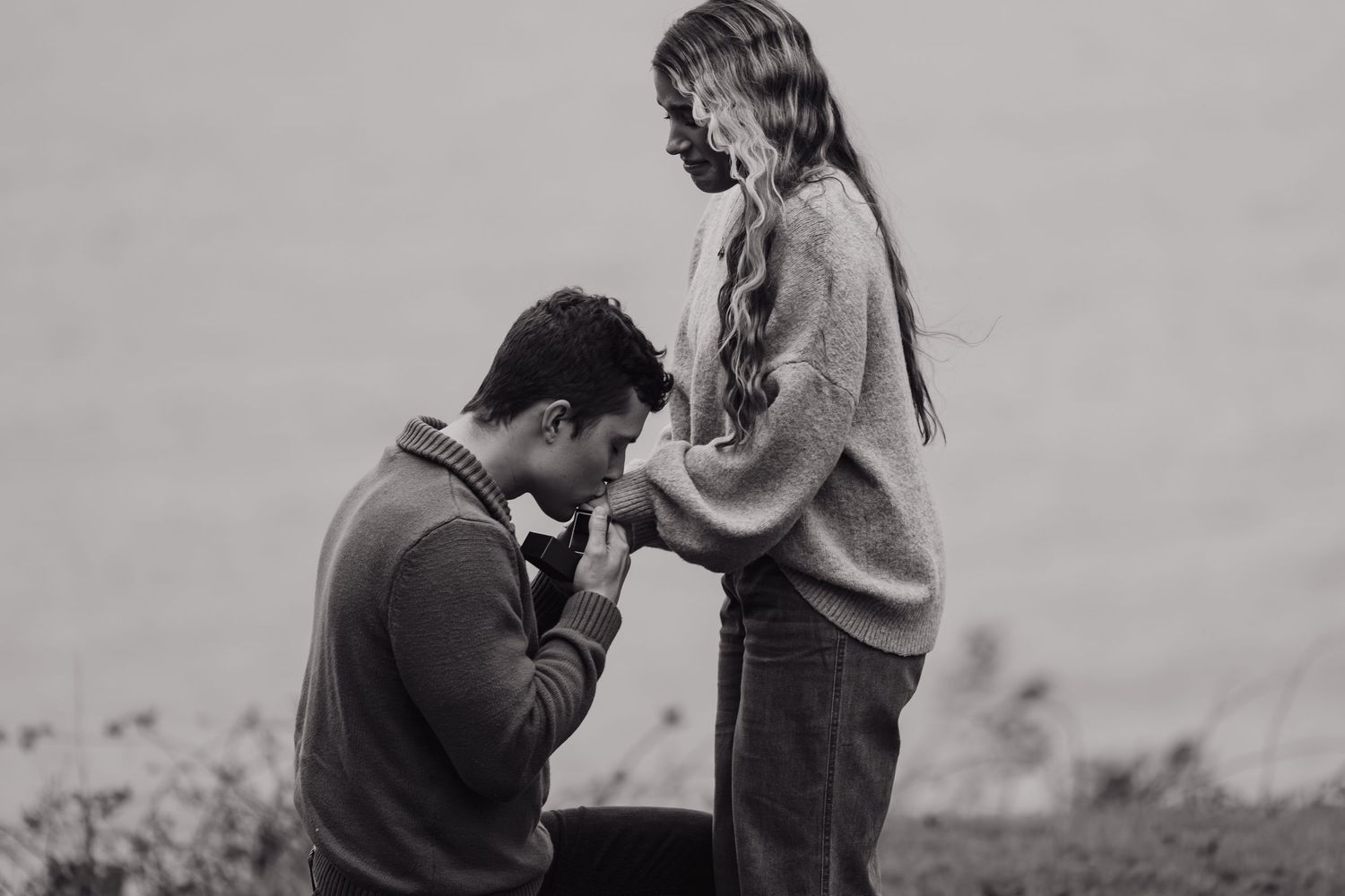 Black and white photo of proposal moment on hillside.