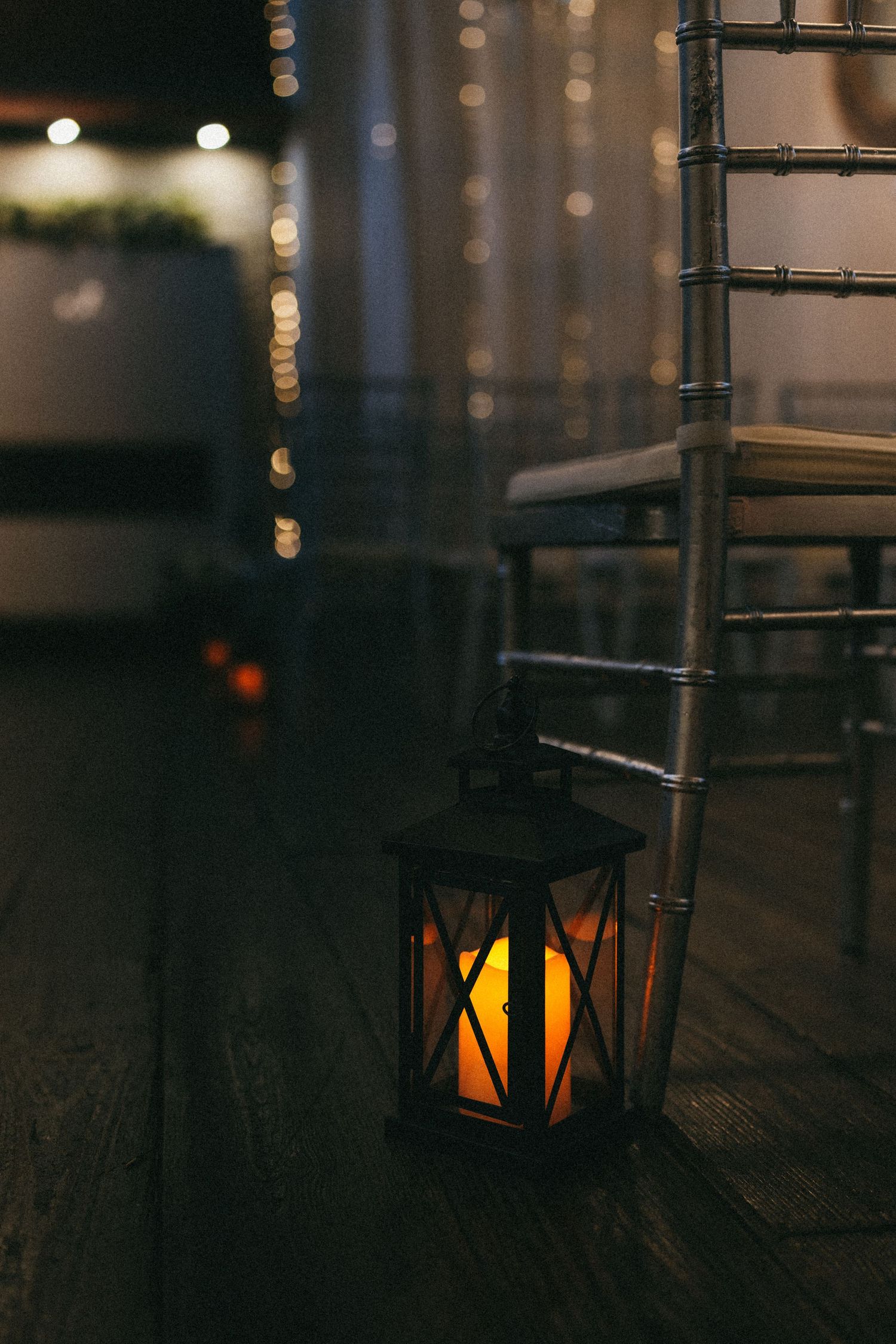 Moody lighting with black lanterns creating ambiance at wedding reception venue.