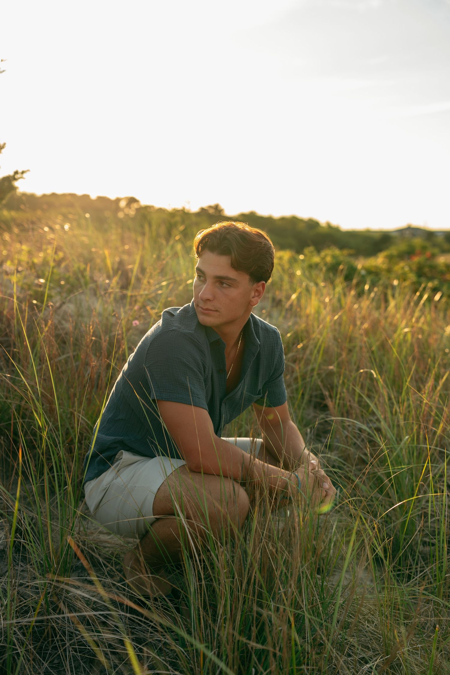 Laid-back portrait session in tall grass during sunset.