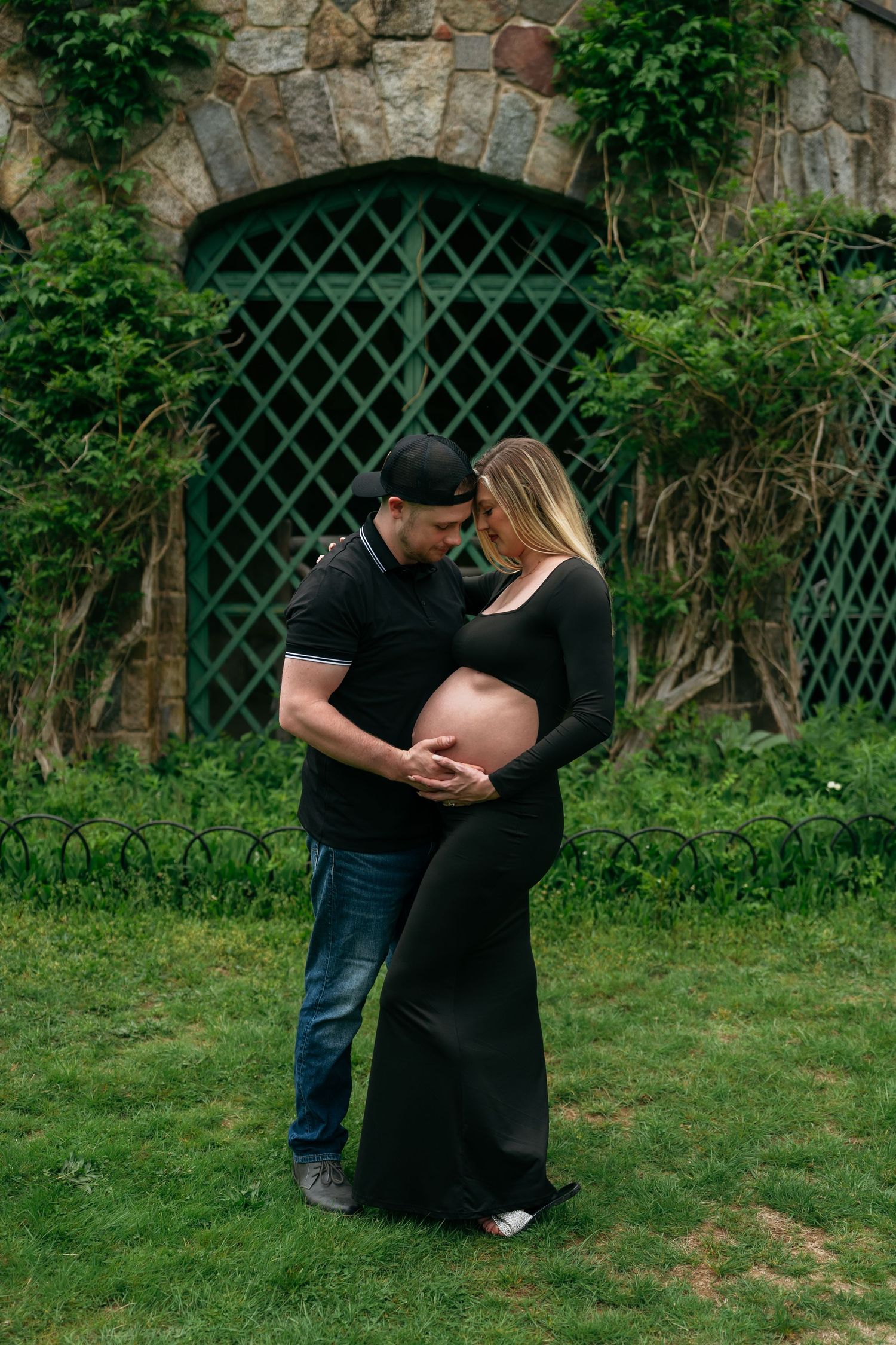 A tender moment between a couple during their outdoor maternity photoshoot.