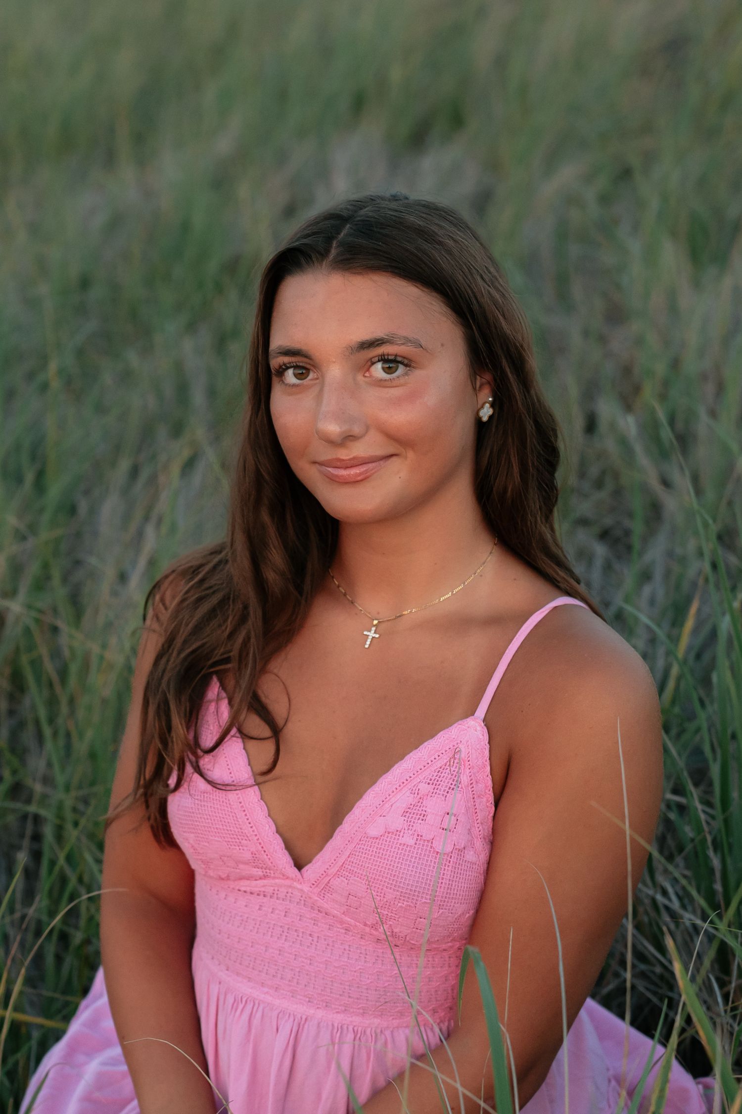 Beach portrait session featuring pink sundress and natural coastal backdrop.