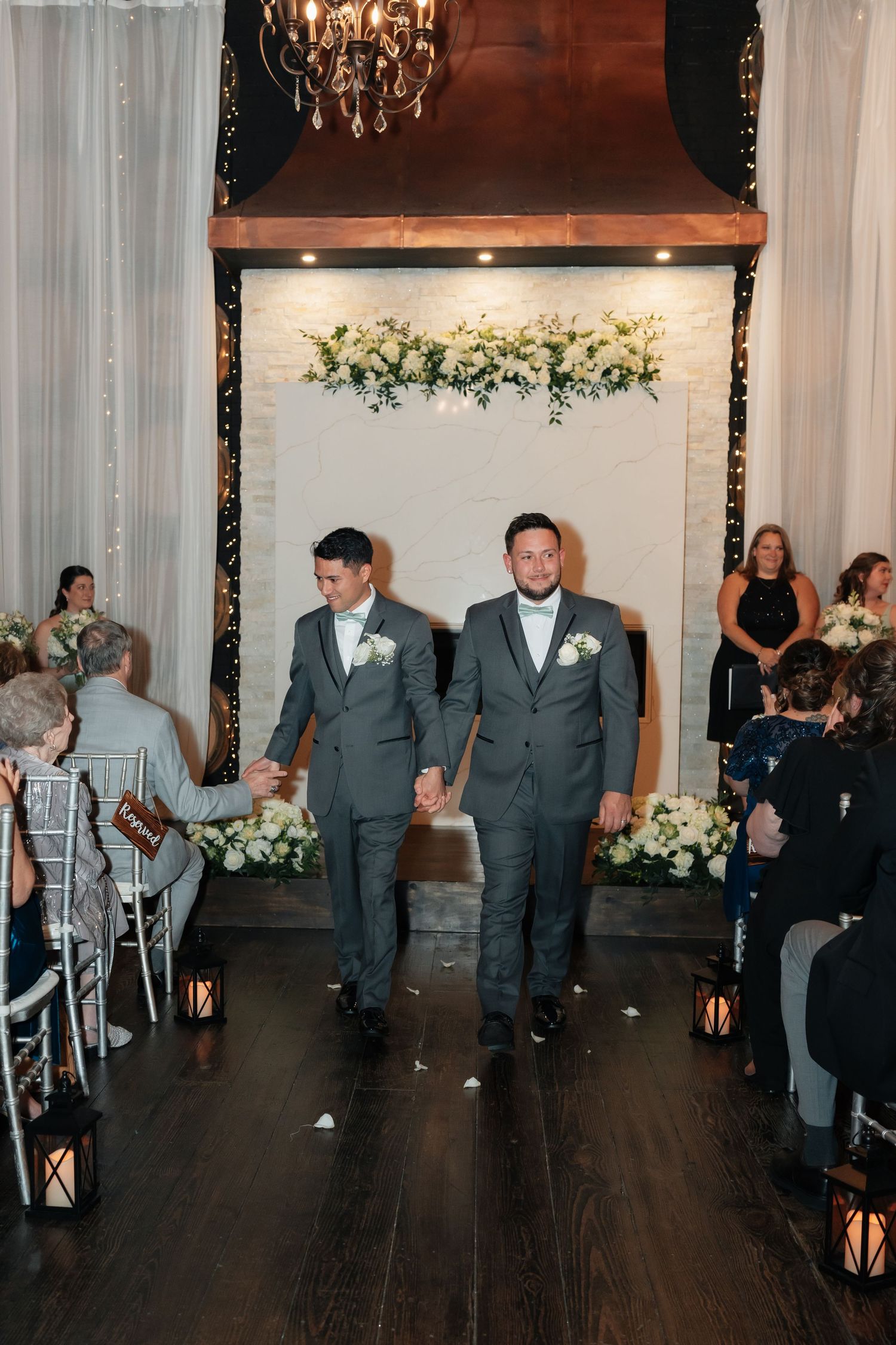 Wedding recessional in an elegant venue with lanterns and floral decorations.