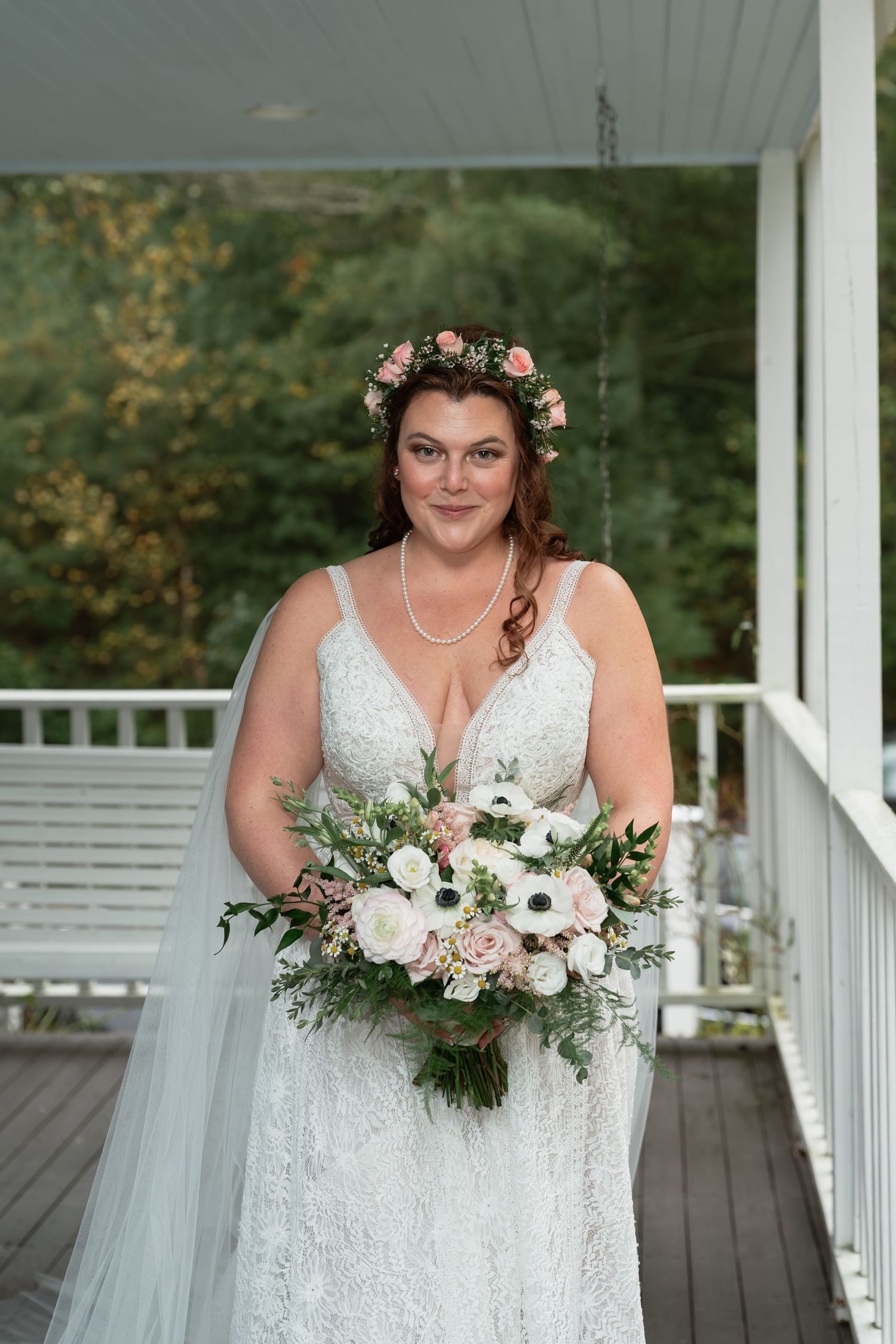 White porch with wooden deck and floral decorations for a wedding celebration.