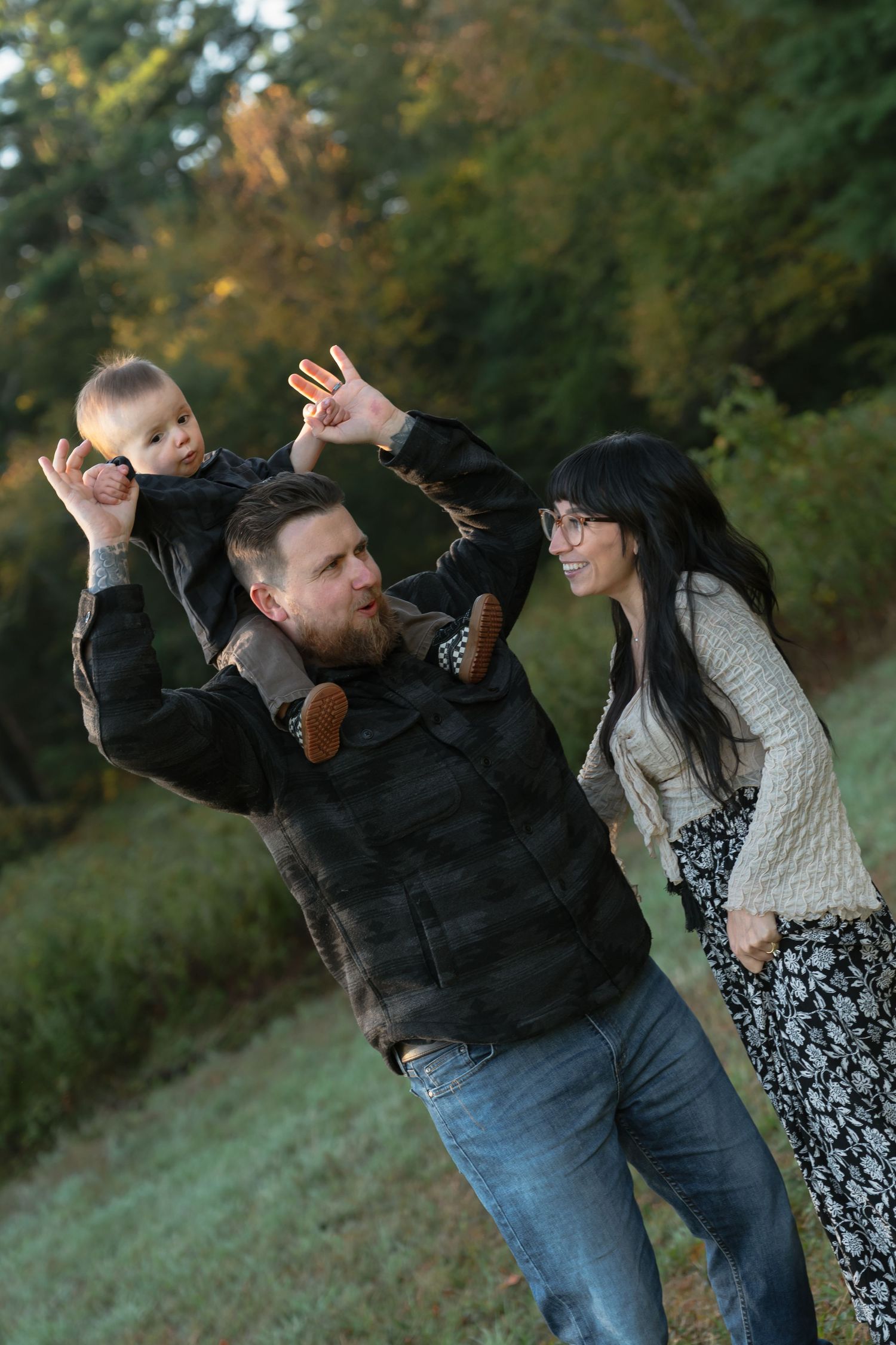Family playing and making silly poses together in an outdoor autumn setting.