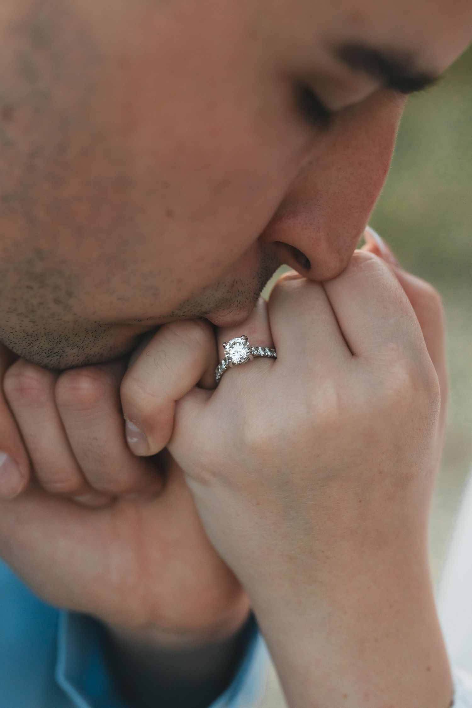 Close-up shot of an engagement ring being shown with a romantic kiss.