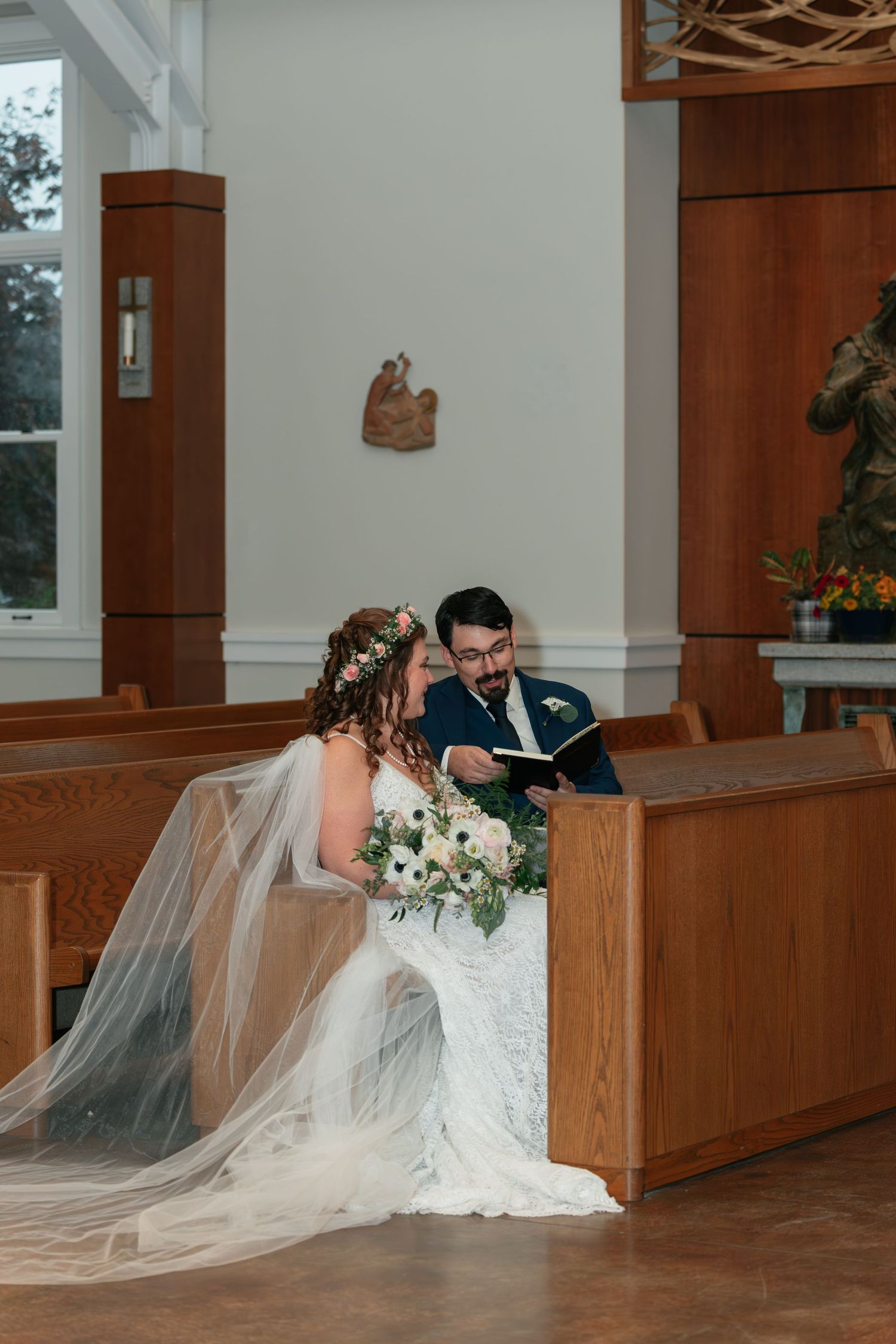 A wedding ceremony in a wooden church with a couple sharing an intimate moment in the pews.