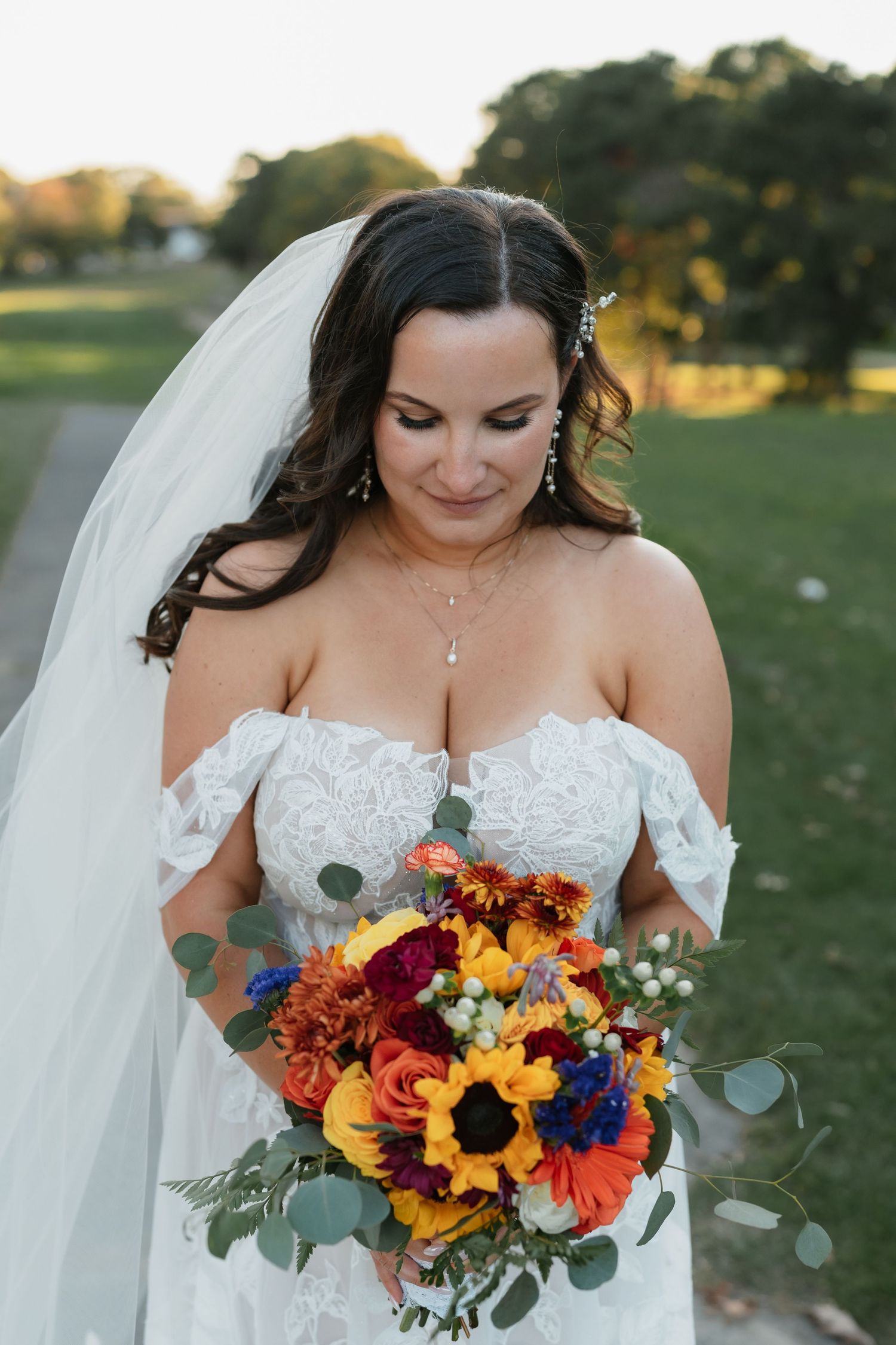 Close-up of bridal bouquet with sunflowers, roses and fall-colored flowers.