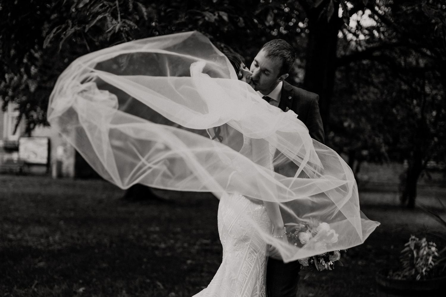Wedding couple walks through a garden with flowing white veil captured in a series of romantic shots.