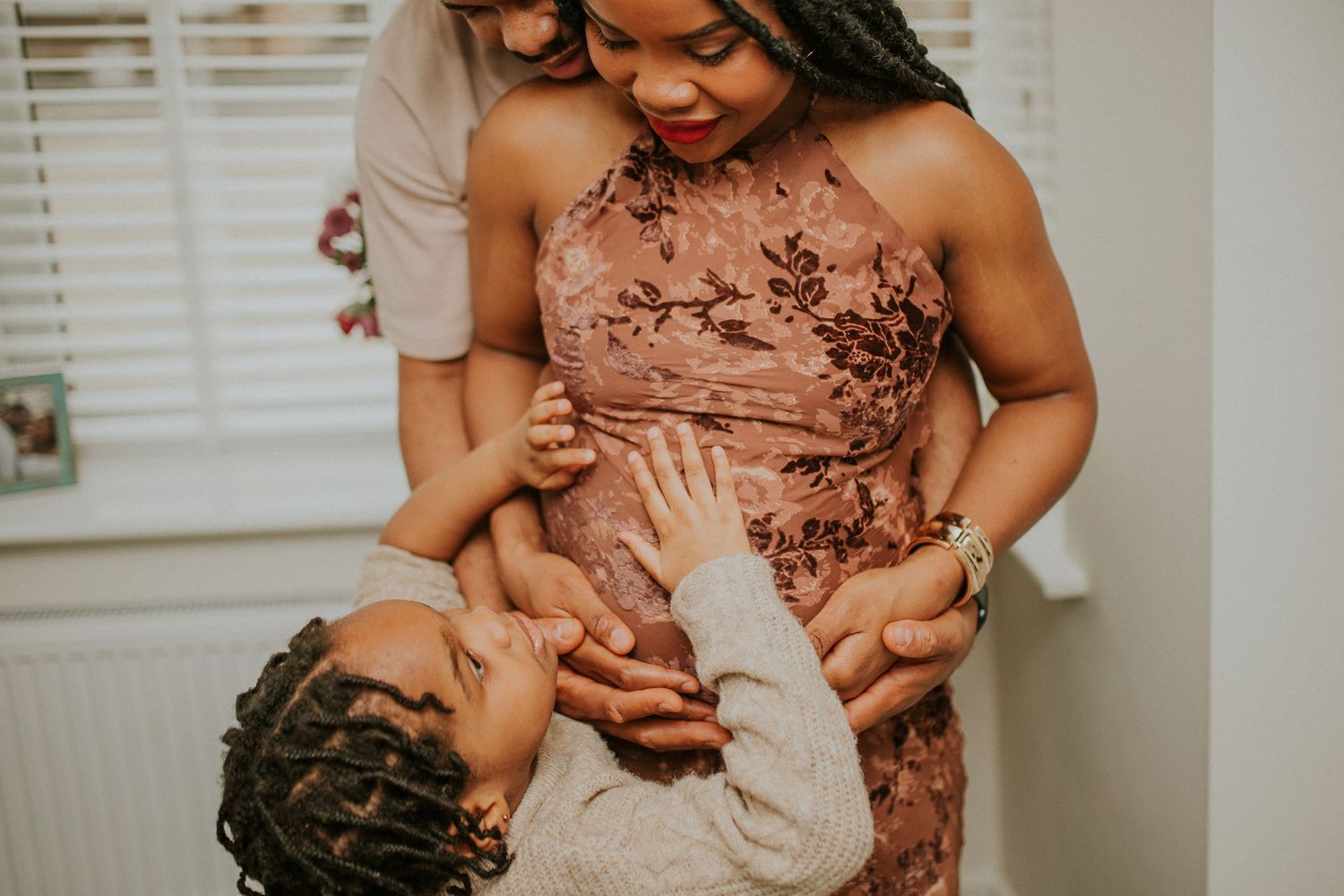 Tender moment between parent and child in matching dusty rose outfits.