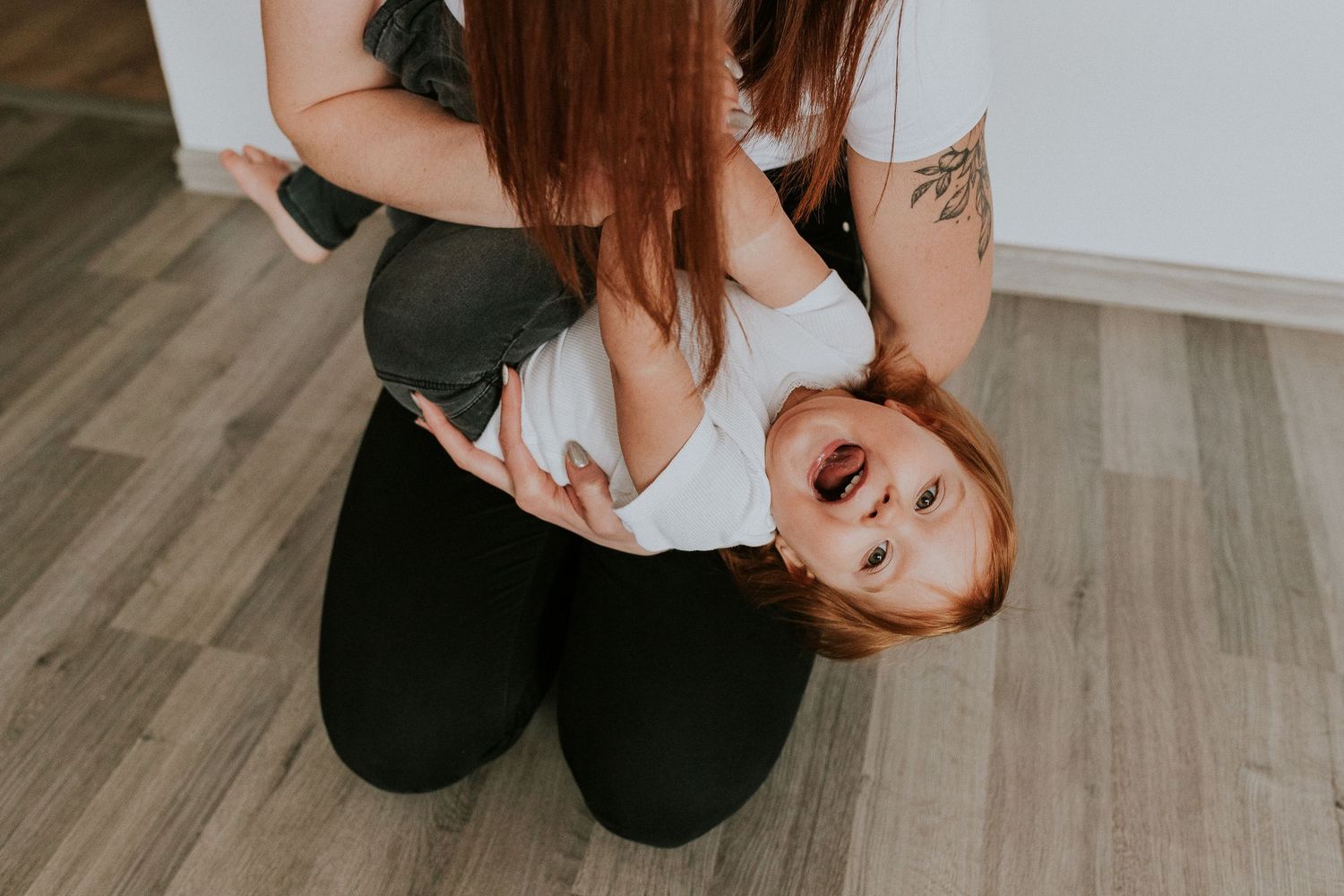Indoor lifestyle photography session with natural poses on hardwood floor.