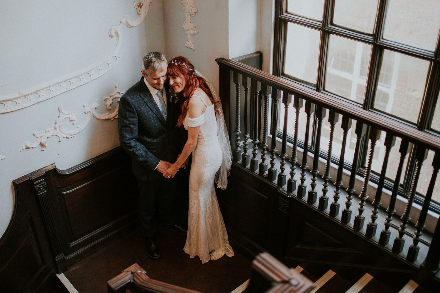 Intimate wedding photos captured on an elegant white staircase with ornate details.