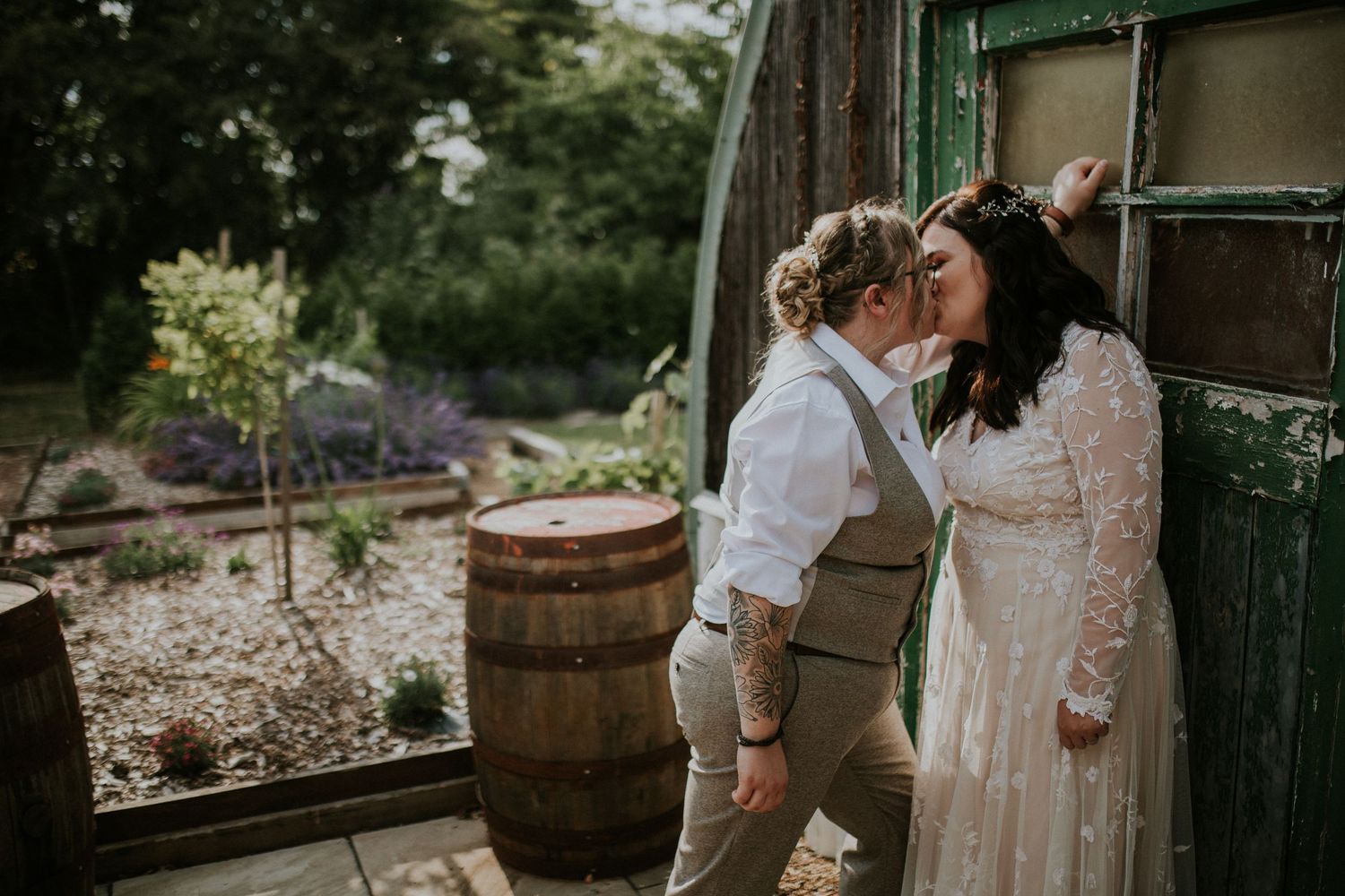 A romantic moment between a couple against a green door in a garden setting.