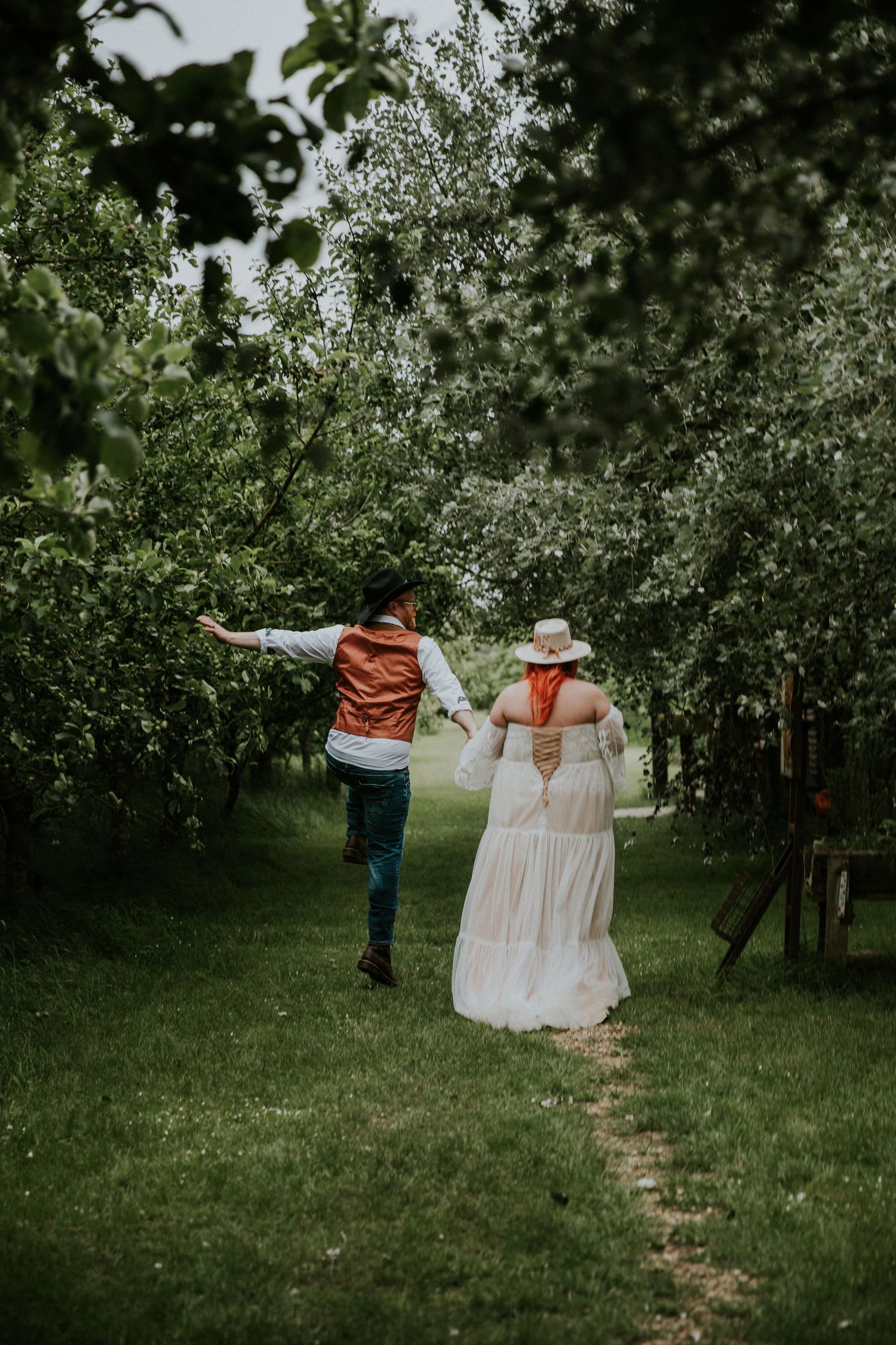 Playful dancing poses captured in an orchard garden setting.