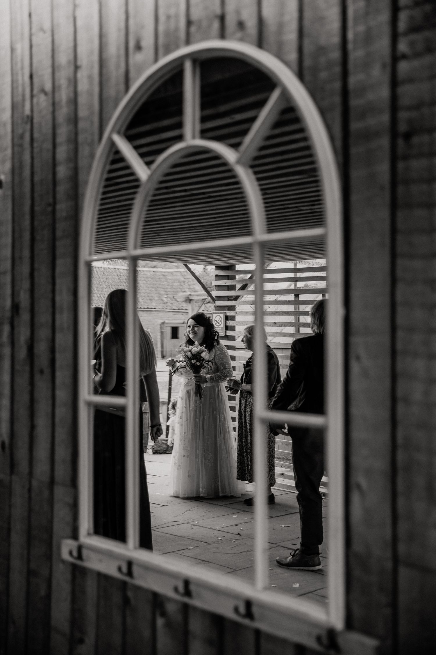 Black and white architectural detail showing arched windows and columns of a wedding venue.