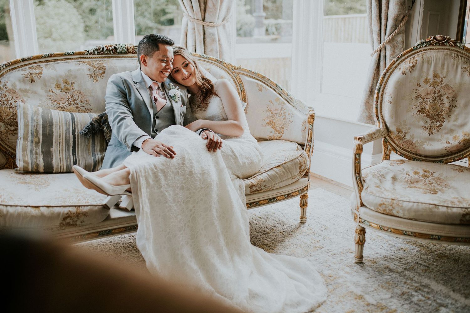 Elegant vintage furniture and decor create romantic bridal portrait setting.