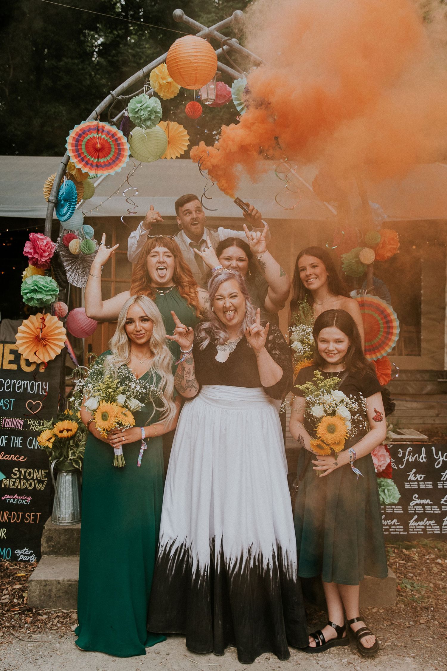 Colorful smoke bomb celebration with party decorations and paper flowers in the background.