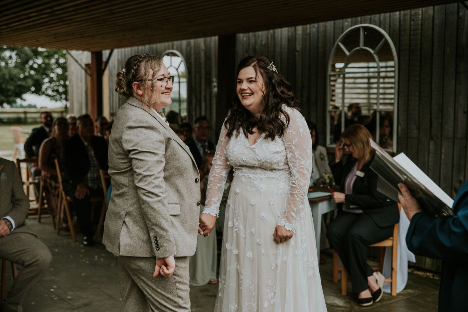 Wedding celebration under a covered outdoor venue with rustic wooden details.