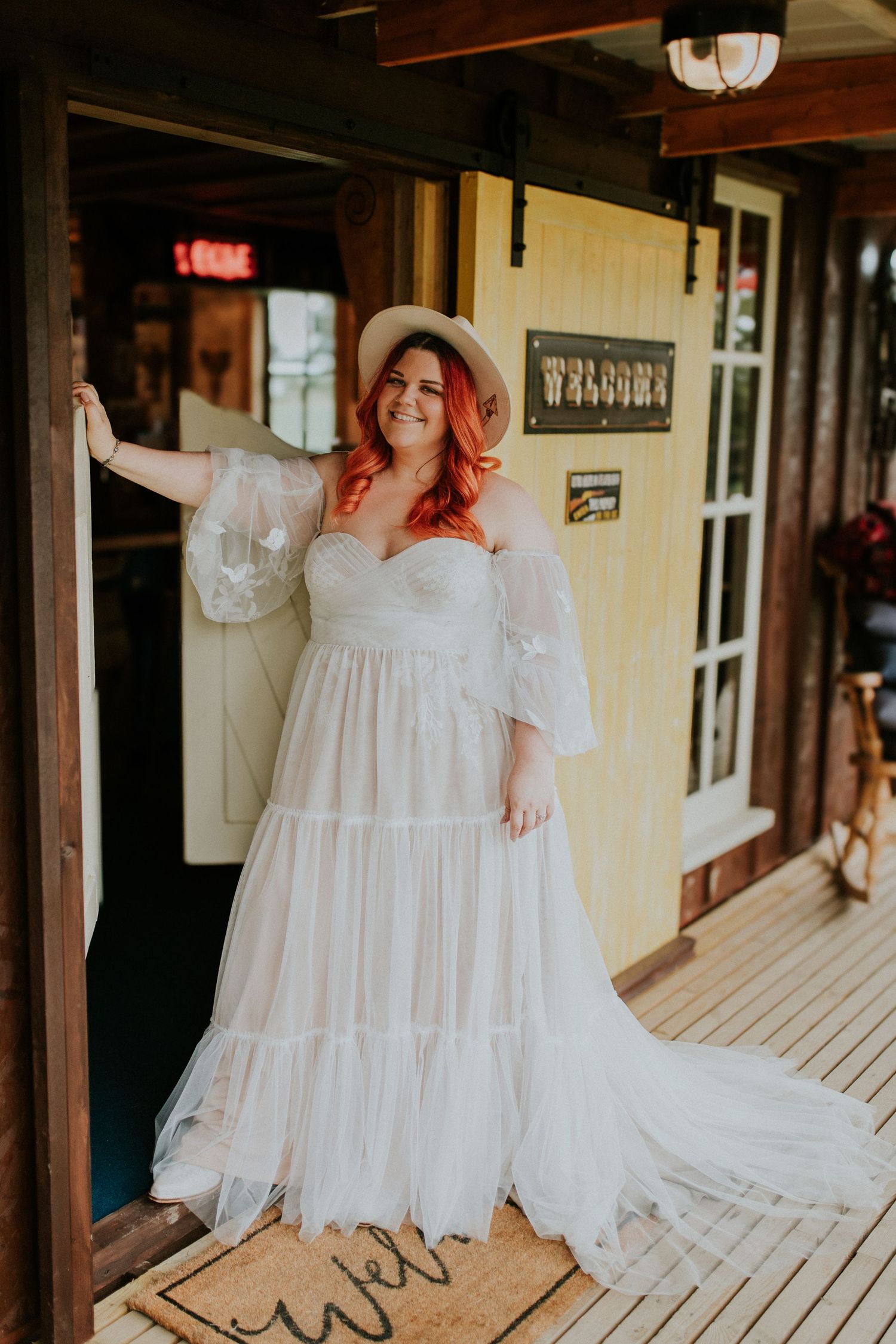 Western-style porch with wooden planks and rustic decorations featuring a flowing white dress.