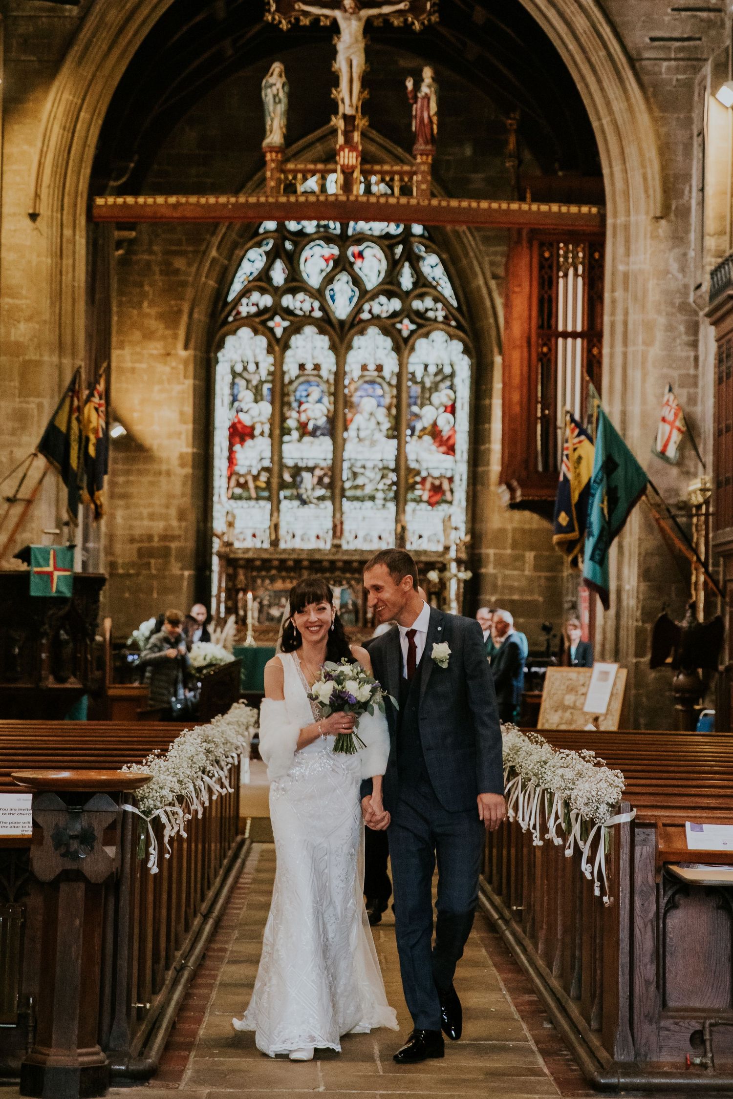 Traditional church wedding ceremony in a stunning Gothic chapel with stained glass windows.
