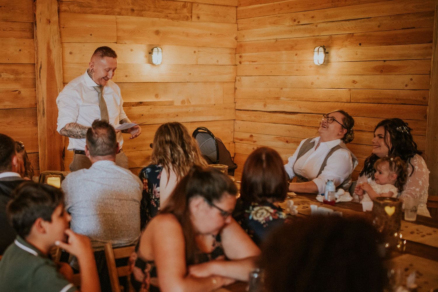 Wedding reception guests gather in a cozy wooden cabin setting.