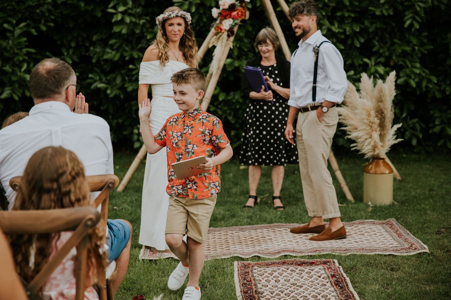 Wedding guests celebrating on decorative rugs during an outdoor reception.