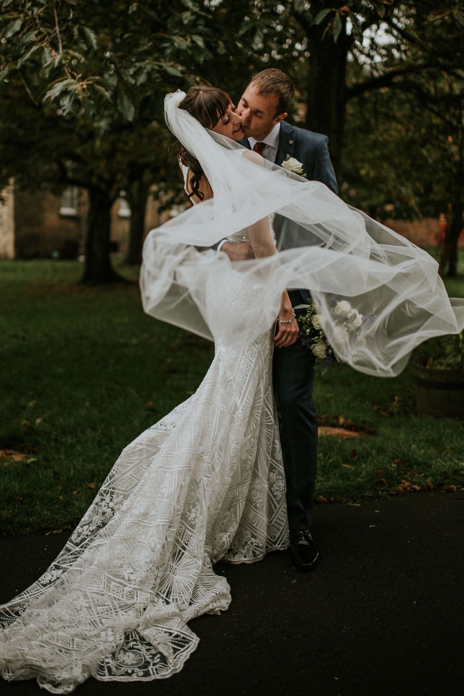 Flowing white lace wedding dress twirling in an autumn park setting.