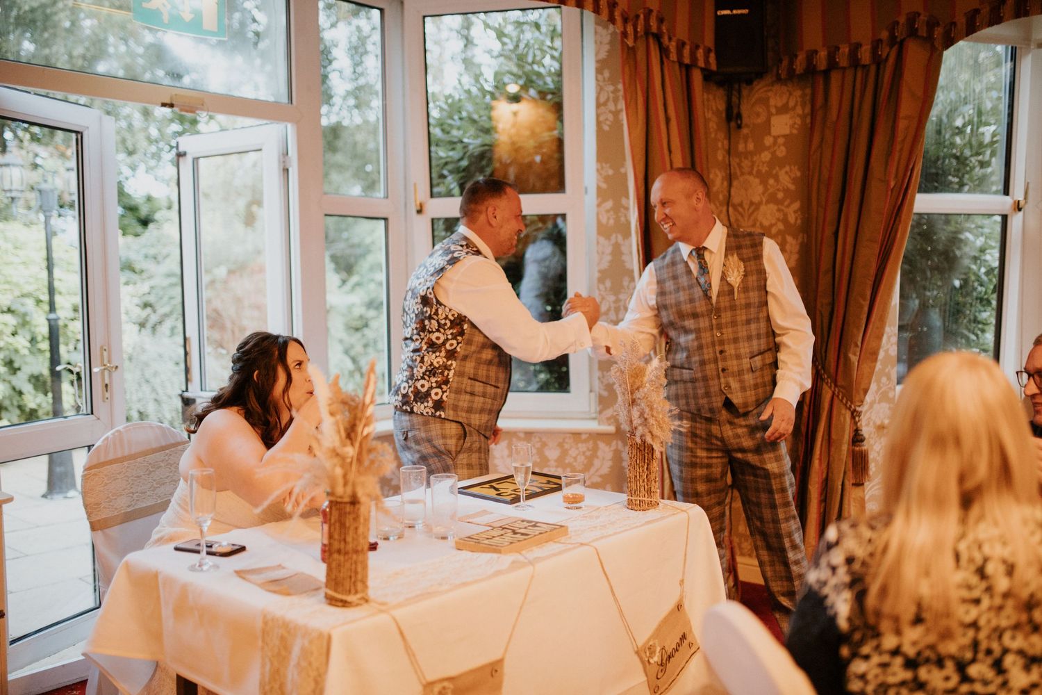 Elegant wedding reception room with large windows and warm lighting.