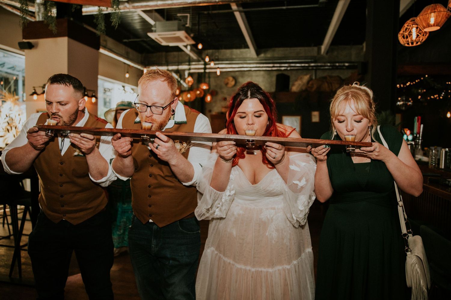 Group of wedding guests blowing bubbles in a candlelit venue.