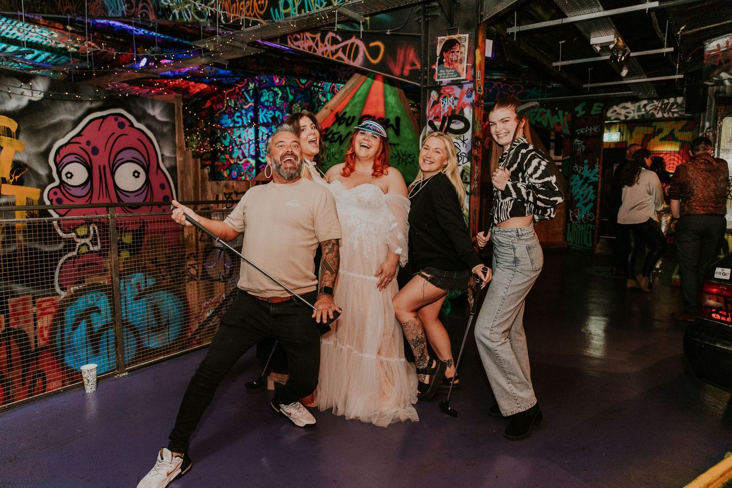 Wedding celebration in industrial venue with graffiti walls and string lights.