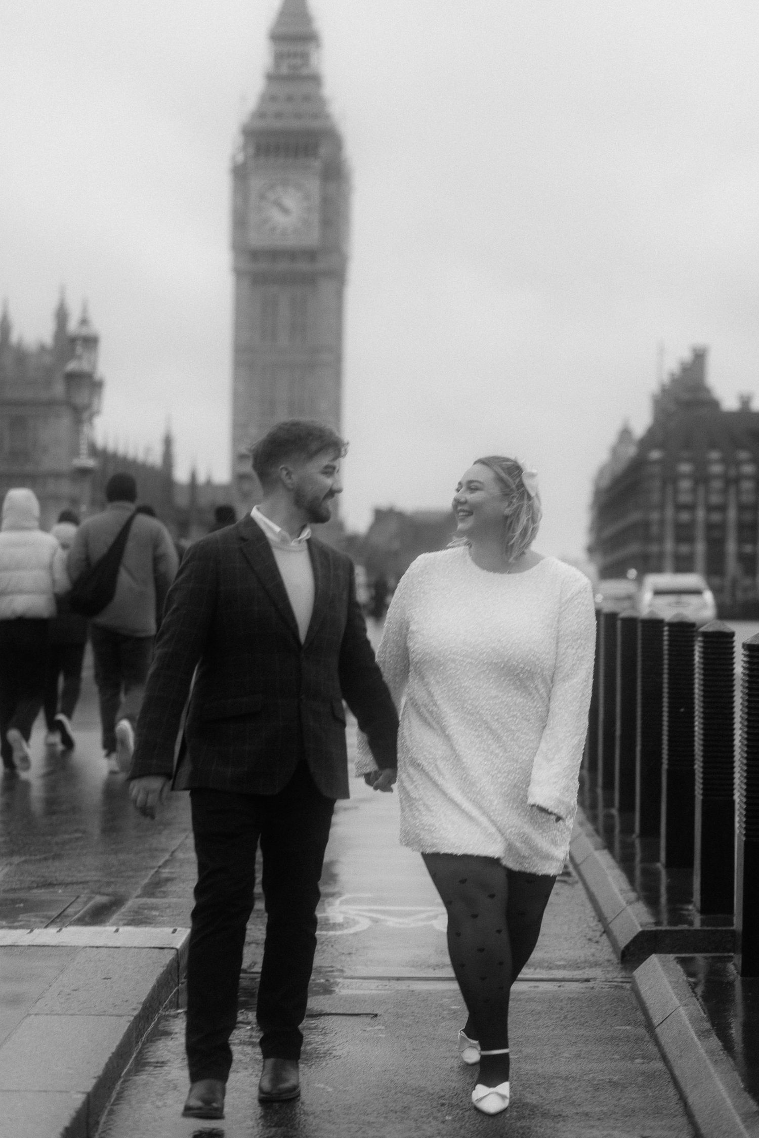 A couple walking together on Westminster Bridge with Big Ben visible in the background.