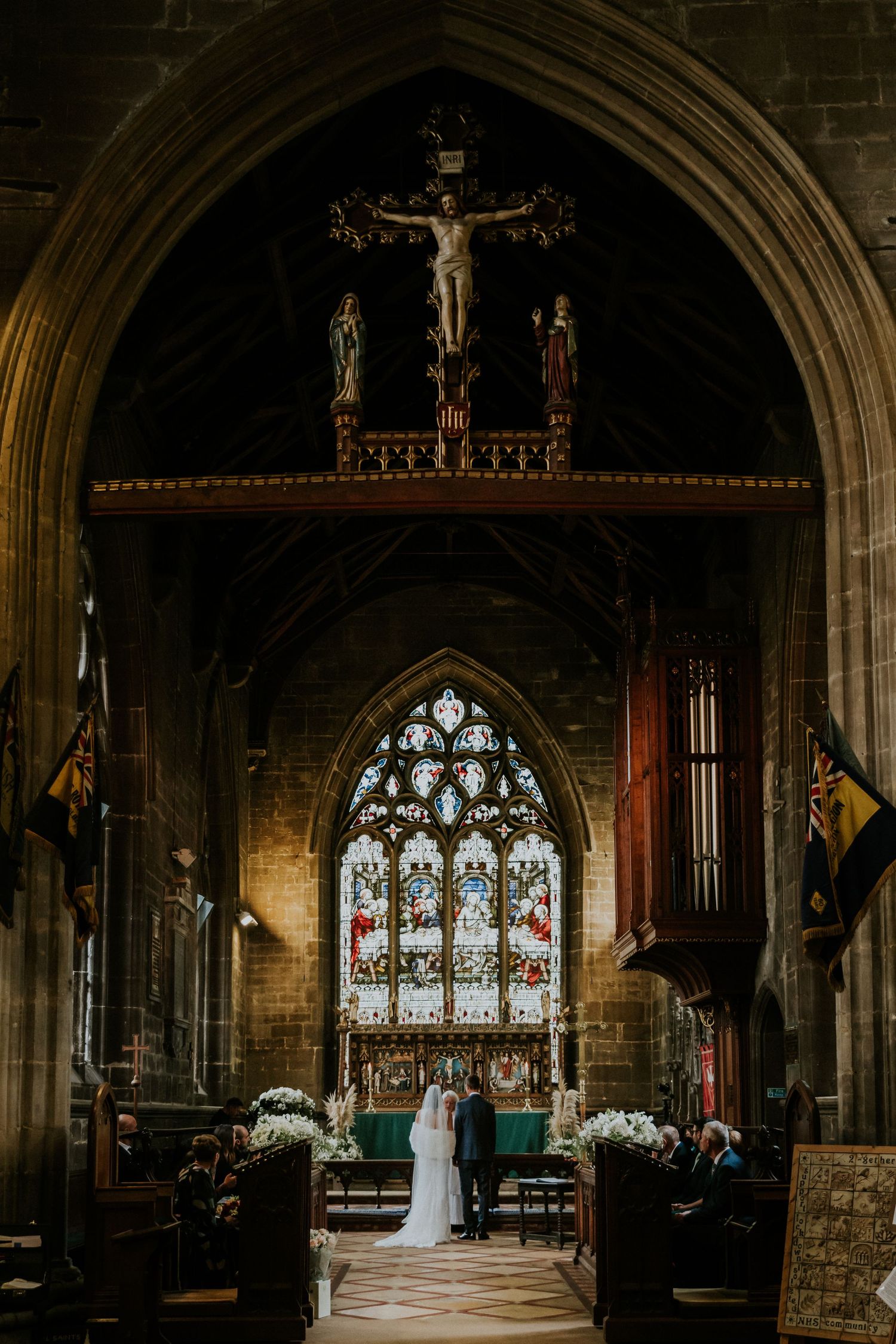 Gothic church interior with stained glass windows and arched ceiling captured in moody lighting.